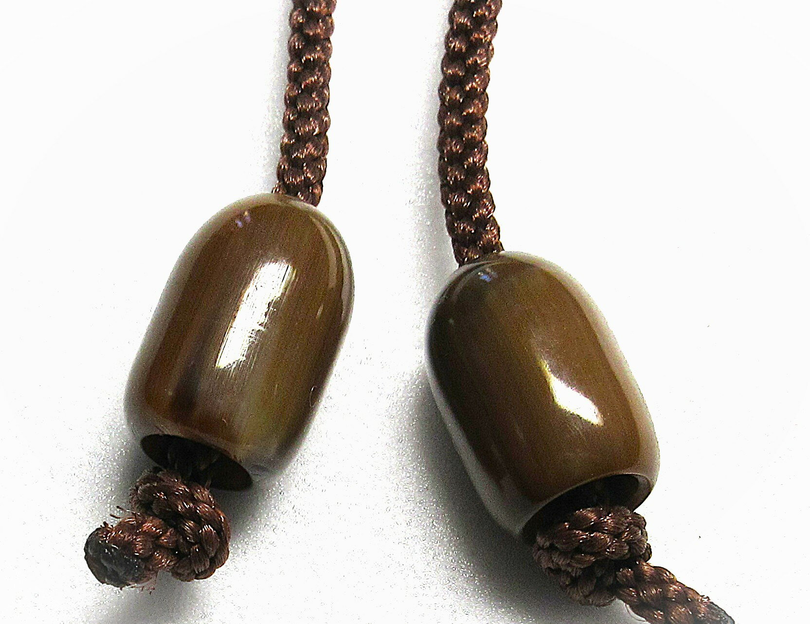 水牛（角）紐止15、なつめ型（大）。特上中濃い茶（天然色）・直径15m/m・長さ23m/m・芯持ち（芯抜き技法）・二段穴、紐穴の径（入り口8.5m/m・出口5m/m）・2個（一対）の価格。紐は付いていません。日本製。ゆうパケット便。