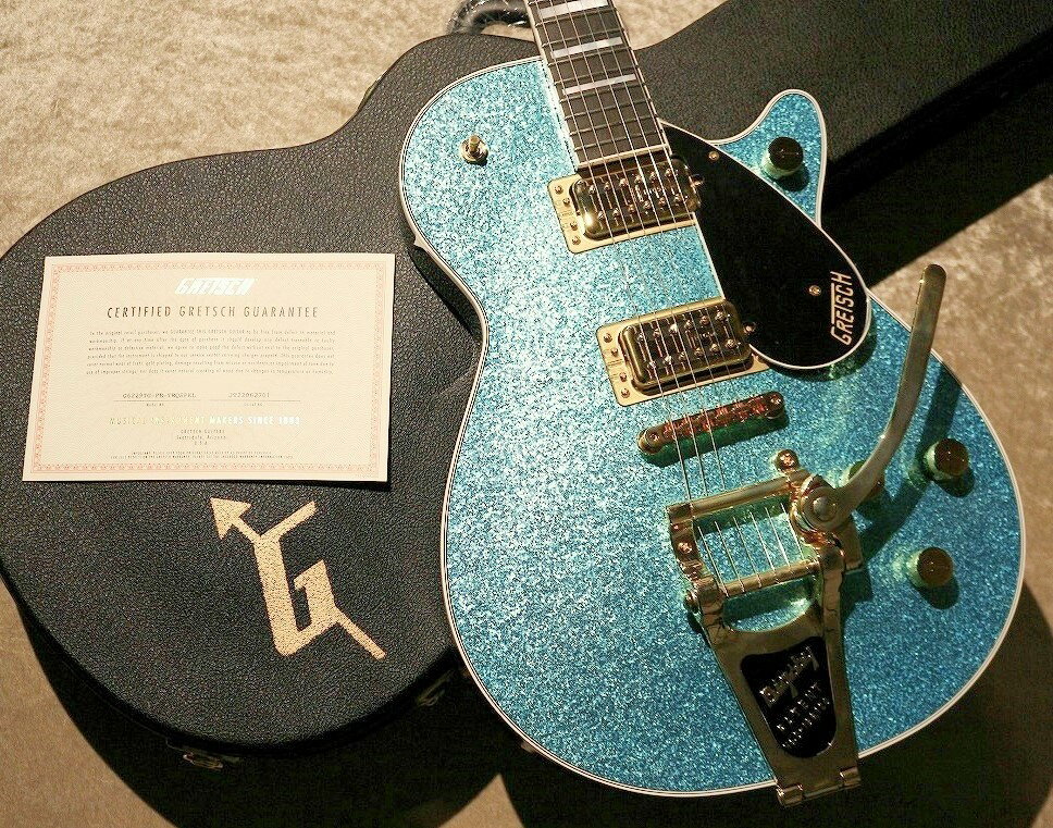 ※ゴールドパーツにくすみがある為、特価品となります。 【G6229TG Limited Edition Players Edition Sparkle Jet ~Ocean Turquoise Sparkle~】 Gretsch Jetはロックンロールの歴史の中で偉大なサウンドをいくつも生み出し、ステージやスタジオで活躍するたびにそのパワーを増強させてきました。この度登場しましたリミテッドモデルは音とパフォーマンスの両方において半世紀にわたる集大成とも言えるモデルです!! 音楽ジャンルとしてどこか偏ったイメージを持たれがちなグレッチですが、昨今その本懐とされるジャンル以外のまったく異なった音楽性を持ったミュージシャン達がこぞって愛用しているという事実は アイコニックな見た目の魅力だけでなくグレッチが楽器として非常に懐が広い「使える」音であることで有るということの裏打ちでもあります。是非その魅力を体感していただきたく存じます。 【特徴】 ボディートップに散りばめられたドラムシェルスパークルは圧倒的な存在感を誇り、Gretsch社のギターとドラムを手がけるメーカーとしての性質と、他のブランドとは一線を画すゴージャスかつルーディーな突き抜けたデザイン性の両面を象徴しているかのようです。 メイプルトップ/マホガニーバックのクローズドチェンバーボディ、マホガニーネック×エボニー指板仕様となります。 非常にのある骨太のサウンドを得意としています。中低域にドスンと重心がありそこに非常にクリスピーでバイト感のある高音域が混ざり合い、ブルース、ロック、ハードロックなど王道のジャンルにおいても非常に親和性の高いサウンドキャラクターです。 Gretschの特徴である澄み切ったクリーントーンは勿論、ドライブさせると焼け焦がすようなディストーションサウンドも抜群に心地よいです。レスポールと比較するとややかすれたドライブサウンドが実にいい味わいを醸し出し、安全圏ではないどこか危うさを孕んだセクシーなロックトーンを演出してくれます。 クローズドボディ、ブリッジベースを介さないダイレクトマウント、プレイヤーズエディションのジョイント構造によりLPモデルのようなハイゲインのセッティングも存分にこなします。非常に凶暴なサウンドで大変お勧めです。 コントロールは3wayトグルスイッチ、マスターボリューム、フロントリアそれぞれ独立したボリューム、マスタートーン仕様となります。各ピックアップのボリュームはセンターポジションセレクト時のフロントリアのブレンド具合の調整に力を発揮します。 マスタートーンはノーロードポットを採用しています。トーンを10の位置に合わせる際クリックのようなかすかな手ごたえがございます。そちらのポジションに合わせている状態はコンデンサーを介さないGretschらしいピュアなサウンドを堪能いただけます。 ～以下メーカー解説及び仕様～ ●太く、音響的に豊かなチャンバード マホガニー どのJet BTモデルも、強く、バランスのとれたミッドレンジを生み出すメイプルトップを備えた厳選されたマホガニーボディから生成され、チャンバードボディは、幅広く調和のとれた豊富でスムーズなアタックと押し広げられた帯域の多様なトーンをもたらします。 ●BroadʼTron™ BT65ピックアップがもたらすパワーとトーン この強力なプラットフォームは、Gretsch BroadʼTron™ BT65によってサウンドが更にパワーアップします。有名なピックアップ製作の匠であるティム・ショーによって設計されたBT65は、緻密にギターのサウンドパレットをキャプチャし、強力な中域音、増強された低音と非常に明確で滑らかな高音を響かせます。空気を揺るがすパワーとフルスペクトルのトーンの完璧な組み合わせにより、比類のないオーバードライブときらめくクリーンをもたらします。 ●Players Editionの快適性、操作性、パフォーマンス プレイヤーの快適さを優先して開発されたJet BTは、フレット間のポジション移動を大幅に向上させる低く設定されたセットネックにより、ピッキング時に高い快適さと精度を提供します。新しいフルアクセス仕様のエッジロール加工されたカッタウェイとテーパードヒールにより、ポジション移動の際に何にも妨げられることなく、スムーズなフィンガリングをサポートします。この洗練されたデザインは、ヴィンテージの隠された美学を保ちながら、見た目だけでは分からない感覚的に捉えることのできる重要な仕様を備えています。Jet BTには、Squeezebox™ペーパーインオイルコンデンサ付ののノーロードマスタートーンポット、トレブルブリードサーキット付きマスターボリューム、個々のピックアップボリュームコントロールなど、トーンとパフォーマンスを自在に操ることができるPlayers Edition機能が追加されています。 ～仕様～ Series: Professional Collection Body Material: Mahogany Neck: Mahogany， Standard U Fingerboard: Ebony， 12 (305 mm) Frets: 22， Medium Jumbo Nut (Material/Width): Graph Tech TUSQ XL， 1.6875 (42.86 mm) Tuning Machines: Gotoh Locking Scale Length: 24.6 (625 mm) Pickups: Broad’Tron BT-65 (Bridge)， (Middle)， Broad’Tron BT-65 (Neck) Pickup Switching: 3-Position Toggle Position 1. Bridge Pickup Position 2. Bridge And Neck Pickups Position 3. Neck Pickup Strings: Nickel Plated Steel (.010-.046 Gauges) お使いの画面環境によって実物と色味が異なって映ることがございます。予めご了承下さいませ。 ※掲載商品売却に対応した在庫表示の反映は迅速を心がけておりますが、 タイムラグが発生する場合がございます。予めご了承ください。 ※各種分割払い(クレジットカード、ショッピングクレジット)ご利用いただけます。 詳しくは担当スタッフまで! 楽器の詳細及び通信販売の手続き方法は、 お電話かe-mailにてお問い合わせ下さい。 ------------------------------------------- 黒澤楽器店 池袋店エレキ本館 東京都豊島区南池袋1丁目25-11 第15野萩ビル B1F TEL 03-3590-9638 Mail: ike@kurosawagakki.com -------------------------------------------