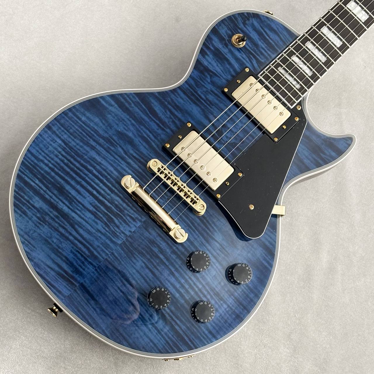 【ショッピングクレジット無金利＆超低金利キャンペーン】 48回払いまで金利手数料0%!!　 [ 54回 2%／60回 2.8% ／84回 7.6% ] ※各種分割払い(クレジットカード、ショッピングクレジット)ご利用いただけます。 詳しくはお電話もしくはメールにてお気軽にお問合せくださいませ。 --------------- momoseやHeadway等の著名なギターブランドを持ち、世界に誇る飛鳥ファクトリーの製造にて自社製品だけでなくOEMも幅広く手掛けている株式会社ディバイザー。 国内のみならず海外でも高い人気を誇り、日々高い品質のギターを製造し続けております。 その中でもアジア生産を中心とし、より手頃な価格の製品をプロデュースし続けているのがBacchusブランドです。 圧倒的なコストパフォーマンスで入門者を中心に高い人気を誇り、低価格帯ではまさに王者と言っても過言ではない指示を獲得しています。 今回入荷したのはレスポールカスタムタイプにフレイムメイプルトップを採用したDUKE-CTM-FM。 ある種Bacchusらしいとも思えるルックスですが、この価格とは思えないほどの拘りが随所に込められております。 何と言ってもこの美しいフレイムメイプルトップが最大の魅力。シースルーブルーのカラーもその美しさを十分に引き立ててくれます。 特にこの個体は直線的な虎杢ではなく、生々しさを感じるダイナミックな杢となっております。 せっかくのフレイムトップですので杢にも拘りたいところ。非常にオススメ出来る良いルックスに仕上がっております。 勿論セットネックジョイントとなっておりますが、どうしてもコストのかかるスペックですので生産本数も比較的控えめ。 しかしながらこの価格でセットネックを仕上げてくれるのは非常に嬉しく、LPタイプをお探しであれば絶対にオススメしたい一本です。 ボディ・ネック材にはニャトーを使用。どちらかというとマホガニーに近い材で、十分な中低域を備えております。 一方でボディ自体はやや薄めとなっておりますので、軽量に仕上がりやすく且つとても抱えやすいのもまた魅力です。 であるが故にサウンドも一般的なLPタイプと比較するとやや軽快ですが、その分抜けが良くバンドアンサンブルの中でも埋もれずに主張します。 勿論ハイゲインにもしっかりと対応し、パワフルなミッド感のあるサウンドは幅広いシーンで活躍する事でしょう。 ハードウェア類にも抜かりは無く、オリジナルパーツ等しっかりと拘ってセレクトしております。 カスタムタイプという事もありゴールドパーツを採用しておりますので、非常に高級感のあるルックスとなっております。 値段を下げつつもクオリティを高いレベルで保ち、入門者だけでなくある程度慣れた方でも関心してしまう程の完成度。 手頃な価格の一本をお探しの方は是非ご検討ください！ Body Top:Nyatoh Body:Nyatoh Neck:Nyatoh Fingerboard:Rosewood Nut:Graphtech TUSQ XL Bridge:T.O.M type Machineheads:Rotomatic Type Fret:Nickel Silver Pickups:Original H-H set Controls:2 Vol, 2 Tone, 3 way PU selector Scale:628mm(24.75inch) Width at Nut:43mm Fingerboard Radius:305R Finish:Polyurethane or Polyester Strings:D’addario 010 ? 046 Accessories:ギグバッグ、保証書、レンチ 【選べる豊富な決済方法】 クレジットカード決済/銀行振込/代引き/ショッピングクレジット --------------- 【ショッピングクレジット無金利＆超低金利キャンペーン】 48回払いまで金利手数料0%!!　 [ 54回 1%／60回 2% ／84回 5% ] ※各種分割払い(クレジットカード、ショッピングクレジット)ご利用いただけます。 詳しくはお電話もしくはメールにてお気軽にお問合せくださいませ。 --------------- 〜通信販売をご利用のお客様へ 〜 掲載商品売却の際、迅速にサイトから削除するよう心がけておりますが、 ショッピングページの更新にタイムラグが生じる場合がございます。 万一ご注文後に売切れとなっておりました場合は、誠に恐れ入りますがご容赦ください。 店舗での試奏やご購入をお考えの方は事前にTEL、またはメールにてご連絡いただければ確実です。 -------------------------------------------------------------------------------- 黒澤楽器店 G-CLUB SHIBUYA 〒150-0043 東京都渋谷区道玄坂2-29-17 Tel: 03-3462-0261（エレキギター） 03-3462-9211（アコースティックギター） 03-3462-0271（ベース） 営業時間:11:00〜20:00