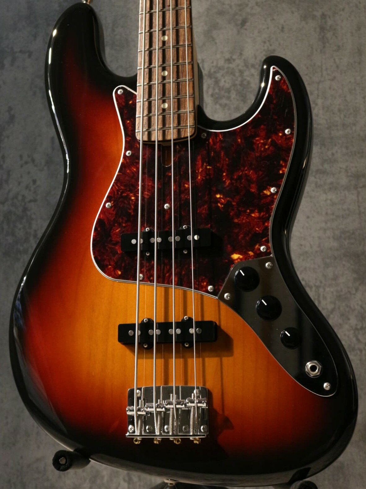 【無金利キャンペーン＆PLEK導入店！】 ショッピングローン48回払いまで無金利キャンペーン実施中！！ 金利手数料0円で憧れの1本を手に入れるチャンスです！！ 更に池袋店は楽器調整用機器PLEK導入店。 ご購入後のメンテナンスもプロの技術で安心してお任せください！ ------------------------------------------ トラディショナルなスタイルでありながら、細部にモダンな仕様を取り入れ人気を博すフジゲン！！ ジョイントプレートには漢字で「富士弦」と刻印され、日本の職人魂を感じます。 エントリー層からの人気が非常に高く、入学シーズンやイベント期間などに良くお選びいただきます。 【入荷個体について】 まず重量は4.11kgと非常に平均的な重量で、重すぎず軽すぎず、理想的な重量感の個体です。 指板のローズウッドも茶褐色と黒色が交じり合う木目となっており、指板の表情の変化もお楽しみいただけます。 サンバーストカラーに身を包むことで、アルダーボディの木目が透けて見えるルックス。 カラーと重量が相まって、非常にスタンダードな1本に仕上がっております。 ※ヘッドに僅かな打痕がございますため、特別価格でご案内いたします。 【パッシブでありながら汎用性のあるサウンドメイク】 サウンドとしては、ヴィンテージトーンでありながらも、切れ味も持たせたモダンな印象も持ち合わせます。 どんなジャンルでも使われてきた、馴染みのある自然な音色でございます。 ピックアップはフジゲンオリジナルです。 スラップはもちろん、指弾きでもしっかりと感じ取れる存在感。 バンドアンサンブルの中で、ギターやボーカルを邪魔せず、ボトムも支える安定感がございます。 Series/Parallel切り替えにより、キレのある伝統的なJBトーンから、PBのような図太いサウンドまで幅広くカバー。 ポップスはもちろん、ファンクやジャズ、パンクでもお使いいただける万能さを持つモデルです。 コントロール部分は馴染み深い2Volume・1Toneという配列。 更にToneノブを引き上げる事で配線を切り変えシリーズ/パラレルの選択が可能となっています。 通常のパラレル接続のスッキリとしたジャズベースサウンド。 シリーズ接続時はプレシジョンベースのようなパワフルなサウンド。 このプッシュ/プルスイッチ一つで、JBとPBの二つのサウンドキャラクターを瞬時に切り替え可能です。 ネックは程よく厚みを持たせたネックですが、厚すぎて握り込めないといった印象は感じられません。 昨今ではエントリークラスの方々にも選ばれるモデルとなっており、人気が高まっています。 暗闇で光る蓄光素材（ルミンレイ）を採用。 ライブステージでの視認性を高めています。 この価格帯での採用は稀です。 【仕様】 アルダーボディ、ローズウッド指板、メイプルネックという木材構成。 エレキベースと言えばあのサウンド！！とも称されるフェンダーと同様で大変馴染みやすいスペックでございます。 ・柔らかくウォームな音色を奏でる ・アンサンブルの中で他を引き立てつつ、低音をしっかりと支える など、ベースの役割をそつなくこなすタイプのスタンダードなスペックです。 ・アルダーボディ アッシュと比較した場合、程よい重量感で甘い音色を得意とし中音域が良く聴こえ暖かみのあるサウンドを形作ります。 ・ローズウッド指板、サークルフレッティングシステム採用フレット、ルミンレイ 茶褐色なルックスで、柔らかく暖かみのあるサウンドを奏でられることが特徴です。 ワシントン条約の関係上、度々代替材を用いられることが多い木材。 フジゲンでは伝統に基づき使用されており、本格的な音色を作り出します。 フレットにはフジゲンの特許技術が採用されております！！ この特許技術は、すべてのフレットを円弧状に打つことで、全ポジションで弦とフレットが直交。 音程のズレや濁りを軽減します。 そのためフジゲン製ベース・ギターは音色の濁りが少なく、透明感のあるクリアなサウンドを奏でます。 ・メイプルネック、Uシェイプ、グロスフィニッシュ ギターやベースで使用される定番の木材でございます。 程よい厚みを持ち、強度と音の太さ、安心感を兼ね備えたネックです。 「太くて握れない！」というようなものではございませんのでご安心くださいませ。 フジゲン製品は木材の製材に手間暇を掛け、水分含有量を調節し、強固なネックを製作します。 時間も手間も掛かりますが、最終的にはネックが反りにくい楽器が出来上がります。 フジゲン製ベースは、比較的ネックが反りにくい印象があります。 メンテナンスでお持ち込み頂いても、ネック調整は必要無い、なんてこともほとんどです。 ・ピックアップ オリジナルの FGN 62J搭載 ・ステンレスジョイントプレート、スクリュー 音の立ち上がりの良さからステンレス製のジョイントプレートとスクリューを採用。 ジョイントネジもステンレス製を採用しておりボディとネックをがっちり接合しサビにも強い仕様。 ボディとネックを強固に接合し、音の立ち上がりとサスティンを向上させています。 大手著名メーカーのOEM製造から得た職人たちの確かな木工・品質。 個体差が少なく、どのベースを選んでも安定したサウンドを得られます。 ベースに不可欠なネックの高い耐久性も確保。 ネックの強さは弦の張りが強いベースと密接に関係してきます。 そのため10万円代の日本製エレキベースとしてはお値段以上のクオリティです！！ この機会にぜひ新たな相棒に加えてみてはいかがでしょうか。 ご購入後の弦交換やネック調整はもちろん、メンテナンスに関するご相談も、お気軽にお申し付けください。 もちろん通信販売も大歓迎でございます。 店頭、通販ともに心よりお待ちしております。 【付属品】 ソフトケース、レンチ、保証書 【SPEC】 Body: Alder Neck: Maple Finger Board: Rosewood, 432mm Scale , CFS , 20F Peg: GOTOH GB2 Bridge: GOTOH 203B-4 (String Pitch = 19mm) Pickup: FGN 62J Control: 2Volume, 1Tone w/ Push-Pull SW (Series/Parallel Select SW) ※金属パーツ類にニッケルメッキが採用されているモデルは経年によりくもりが発生します。ニッケルの特性上入荷時より僅かに曇っている場合がございますのでご了承ください。 ※お使いの画面環境によって実物と色味が異なって映ることがございます。予めご了承下さいませ。 ※掲載商品売却に対応した在庫表示の反映は迅速を心がけておりますが、 タイムラグが発生する場合がございます。予めご了承ください。 ※各種分割払い(クレジットカード、ショッピングクレジット)ご利用いただけます。 詳しくは担当スタッフまで! 楽器の詳細及び通信販売の手続き方法は、 お電話かe-mailにてお問い合わせ下さい。 ------------------------------------------- 黒澤楽器店池袋店エレキ本館 東京都豊島区南池袋1丁目25－11 第15野萩ビル B1F TEL 03-3590-9638 Mail: ike@kurosawagakki.com -------------------------------------------