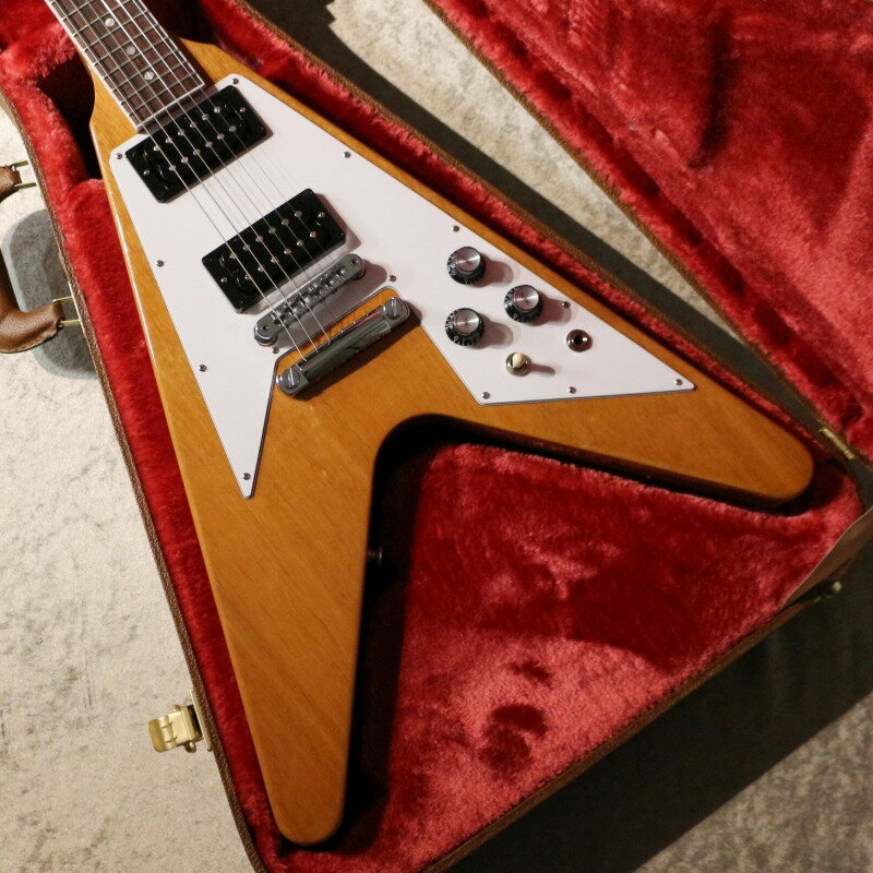 この度の入荷は元祖変形ギターとも言えるFlying V です！ 70sスタイルに新たに追加となったアンティークナチュラルカラーとなります！この見た目、カラーを求めていた方も多いでしょう！ フライングVは見たままですがVとも矢印とも云われるボディ形状をしております。音のためでもプレイアビリティのためでも重量バランスのためでもなく、ステージでのかっこ良さのみを追求して考案されたそうです。 フライングVは1958年から1960年にかけて革新的なギターとして発表、販売されましたが、時代に合わずあえなく生産終了となります。斬新すぎたその見た目が受けいられませんでした。 Flying Vが再生産されたのは1967年のことです。現在ではハードロックやメタル等のジャンルで活躍しておりますが、復活までは時間を置くことになりました。 入荷の個体は70年代スタイルとなっておりカラーはアンティークナチュラルカラー、仕様はマホガニー・ボディ、マホガニー・ネック、ローズ指板・ミディアムスケール、ネックはスリムテーパーを採用しています。非常に握りやすいネックで演奏性は抜群です。指板も良質！ 何といっても70s後期に見られたネックホワイトバインディングの施されたルックスは必見です。ネックバインディングによるカッコよさとアンティークナチュラルによるクールな佇まいで是非抱えてほしいです。 更にドットポジションやブラックエスカッション、丸ヘッドなど、マニア向けの仕様も必見！ サウンドの要のピックアップには新開発70s Tributeを搭載。弾いてみました印象は中域から高域にパワフルさがあり、非常に明るいサウンドが特徴のピックアップとなります。そのため歪みのノリが非常によく倍音も豊かで、まさにギタリストがこれだと叫びたくなるサウンドを体感できます。アリーナクラスのステージにも対応できるでしょう。 ハンドワイヤリング配線されたエレクトロニクスとなっておりオレンジドロップキャパシタ―も標準搭載となります。サウンドの明瞭さに貢献している点です。 コントロールは2Vol、1Tone、1トグルスイッチ（ピックアップセレクター）、ブリッジはナシュビルチューン・オー・マチック＋ストップテイルピース、ペグは信頼のGROVER製です。 これらの仕様から繰り出されますサウンドは正しく王道。暖かみのあるクリーンから攻撃的なドライブサウンドまで刺激的です。ボディ形状だからこそ得られる軽く、甘く、柔らかいサウンドが、フライングVの個性であると言えます。 変形ギターの恩恵かもしれませんが歪ませた時に感じる粘り、食いつき感がなんともたまらなく絶妙だと思いますのは気のせいでしょうか？ 是非お早めにどうぞ！ ~以下メーカーページより～ 70年代ロックサウンドにおけるアイコンモデル！ アイコン的ステータスの70sフライングVが再び飛び立つ時がやってきました。バインディングの施されたローズウッド指板、スリムテイパー・ネック、オレンジドロップ・キャパシターとハンドワイリング配線された70sトリビュート・ハムバッカー・ピックアップを伴い、70sフライングVは往時のクラシック・トーンを確実にもたらします。マッチング・ヘッドストック仕様のクラシック・ホワイト、シルヴァー・トップ・ハット・ノブ、クローム・ハードウェアを纏い、アリーナクラスのステージへ向け、準備万端です。 ~Spec~ Body Body Shape:Designer Body Material:Mahogany Finish:Gloss Nitrocellulose Lacquer Neck Material:Mahogany Profile:Slim Taper Scale Length:24.75" / 628.65mm Fingerboard Material:Rosewood Fingerboard Radius:12" Number Of Frets:22 Frets:Medium Jumbo Nut Material:Graph Tech Nut Width:1.69" / 43.05mm End of Board Width:2.26" / 57.4mm Inlays:Acrylic Dots Hardware Finish:Chrome Bridge:Aluminum Nashville Tune-O-Matic Tailpiece:Aluminum Stop Bar Tuning Machines:Grover Rotomatics w/ Kidney Buttons Pickguard:White 3-ply Control Knobs:Black Top Hats with Silver Reflector Switch Tip:Cream Electronics Neck Pickup:70s Tribute Bridge Pickup:70s Tribute Controls:2 Volumes, 1 Tone & Toggle Switch (Hand-wired with Orange Drop Capacitors) Strings:.010, .013, .017, .026, .036, .046 Case Case:Hard Shell Case ※お使いの画面環境によって実物と色味が異なって映ることがございます。予めご了承下さいませ。 ※掲載商品売却に対応した在庫表示の反映は迅速を心がけておりますが、 タイムラグが発生する場合がございます。予めご了承ください。 楽器の詳細及び通信販売の手続き方法は、 お電話かe-mailにてお問い合わせ下さい。 黒澤楽器店池袋店エレキ本館 東京都豊島区南池袋1丁目25－11 第15野萩ビル B1F TEL 03-3590-9638 Mail: ike@kurosawagakki.com