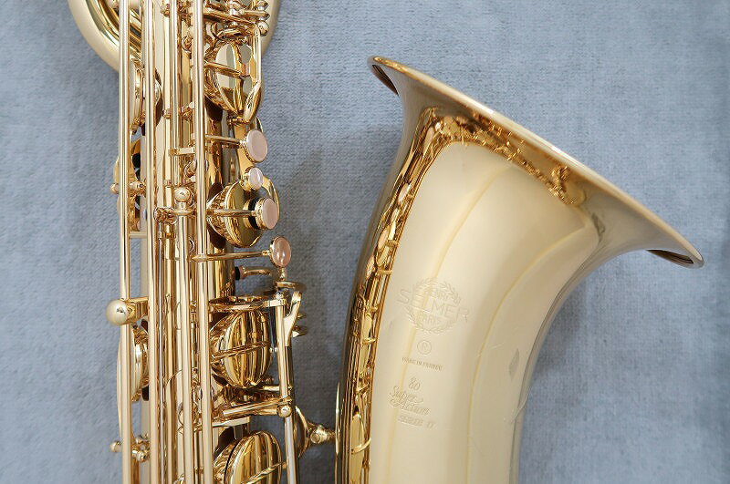 H.Selmer 最初の工房が開設されて以来130年以上の実績があるフランス最初の総合管楽器メーカー。 現代サックスの礎を築き上げてきたトップブランドです。 現在はサクソフォン・クラリネット・マウスピースなど幅広く生産をしています。 &nbsp; 豊かな経験と知識を身に着けているセルマー社のスタッフと 洗練された最先端の製造工程で製造しており 部品製造から組み立て完成まですべてをフランスで行っています。 1921年の最初のサクソフォンから現在のラインナップまで数多くのモデルを発表し 多くの演奏家たちから愛用されているメーカーです。 SA80II BaritoneSax SA80II(スーパーアクション80 シリーズ2)は セルマー社の基本となる機種でもありソプラニーノからバスまでそろえており 長年の間多くのアーティストから愛用され続けているセルマーを代表とするモデルです。 SA80IIのバリトンサックスは全音域でむらがなく反応が正確なモデルです。 高音域も鳴らしやすく、最新の現代音楽にも対応ができます。 あたたかく、柔らかな音色でキー設計の改良によりレスポンスのい良い操作性が可能となりました。 シリーズ2はシリーズ3よりも重厚感のあるまとまったサウンドが特徴のモデルで ネックにロゴプレートを採用しておりシンプルで抜けの良い豊かでストレートな響きを実現しています。 ベル支柱の台座は接着面積を広くするように台座を多く使用し、安定した力強いサウンドとなっています。 ※入荷時期によって彫刻や色合いなどが異なる場合もございます。 仕様・付属 【仕様】 ・調子E♭(バリトンサックス) ・仕上げ:ゴールドラッカー仕上げ ・LowAキー付き ・ネック &nbsp; (重厚感のあるまとまった響きを求めロゴプレートの採用) ・ベル支柱台座 &nbsp; (接着面積を大きくし安定感のある力強い音を実現) ・彫刻あり 【付属品】 ・ケース・メーカー保証 ・マウスピース・リガチャー・キャップ・ストラップ ・リード・クリーニングスワブ・コルクグリス・クロス &nbsp; Shop Information 【サキソフォン・ラボ　商品一覧】 【保証期間】 新品・アウトレットには当社5年間、中古品は当社6か月の保証でご案内しております。 リペアマン常駐でご購入後のアフターケアもお任せください。 &nbsp; 【納期】 在庫があるものにつきましてはおおよそ当日・翌日の発送となります。 WEB更新の都合上、商品が売り切れとなっている場合もございます。 お急ぎの場合は事前に在庫の確認をお申し付け下さい。 ※発送はお支払い確認後となります(代引きを除く)。 ※諸事情により出荷にお時間を頂く場合もございます。 ※お取り寄せ商品、入荷待ち商品に関しましては別途納期のご連絡をさせて頂きます。 【梱包】 梱包には細心の注意を払ってお届けをさせて頂いておりますが 当店ではエコ梱包を心がけており再利用段ボール使用や 頑丈なパッケージ商品は段ボールを使用せず気泡緩衝材を使用する場合がございます。 　 【サキソフォン・ラボ】　　　　　　　　　　　　　　　　　　 〒169-0073 東京都新宿区百人町1-10-8 3階 TEL:03-3363-9630 Mail:wind@kurosawagakki.com