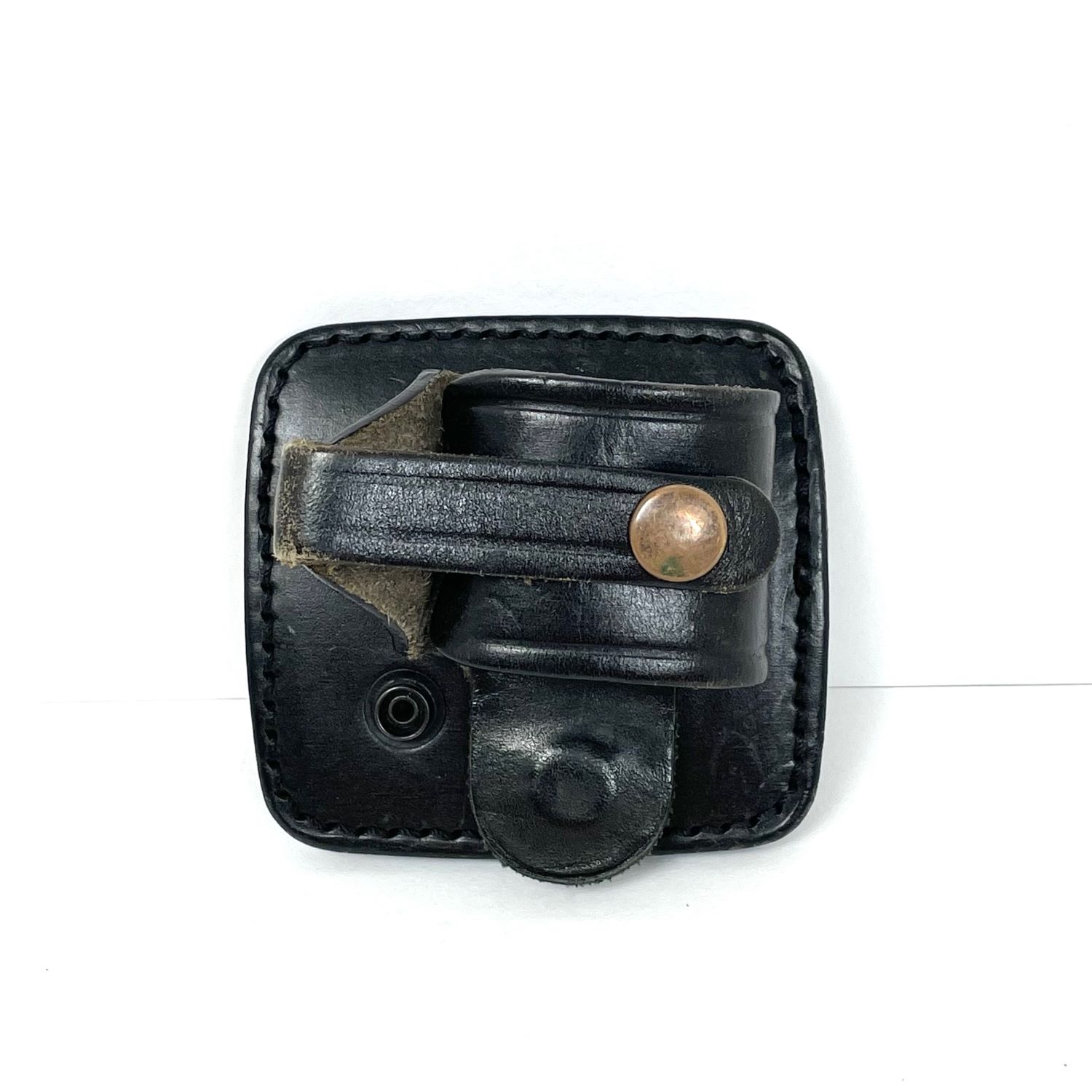 イギリス PWL RCL-3 レザーハンドカフホルダー USED /myb メーカー: Price Western Leather (PWL) 型番: RCL-3 (RCL3) 素材: 本革（ブラックレザー） 対応ベルト幅: 約5cm（2インチ）までのポリスデューティベルトに装着可能 イギリスの警察装備メーカーであるPWL（Price Western Leather）社製のレザーハンドカフホルダー「RCL-3」（Speedcuff Loop / Rigid Cuff Pouch with Swivel） イギリス警察（ポリス）の実物放出品としてミリタリーサバゲーマーやポリスマニアの間で非常に人気の高い装備品です 「スピードカフ（リジッドカフ）」専用設計 左右の輪がチェーンではなく、強固な金属や樹脂のヒンジ・継ぎ手で固定されている「リジッドタイプ（硬質・一体型）」の手錠に対応しています イギリス警察で広く使われている手錠（Hiatt社製など）にジャストフィットする構造です 背面のベルトパネルと本体を繋ぐスナップボタンを付け替えることで、ホルダーの角度を3段階に変更（スウィベル）できます 自分の抜きやすい角度（垂直、あるいは斜め）に固定できるため、座った状態や動いている最中でのドロウ（引き抜き）がスムーズになります 手錠の継ぎ手（ヒンジ）部分にバンドを巻き付け、スナップボタンで固定するオープンブラケット（オープントップ）スタイル 親指で素早く外せる（Thumb Break）構造でありながら、不用意に脱落しないよう確実な保持力を持っています PWL社は30年以上の歴史を持つイギリスの老舗ブランドで、天然の植物オイルで鞣された最高級の英国産ハイド（牛革）を使用しています 実物放出品（中古）であっても、使い込むほどに味が出る頑丈な革質が特徴です サイズは　9．5cm　×　9．5cm1個のみメール便250円OK