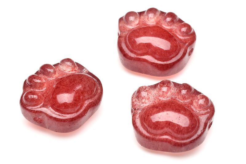 材質レッドアベンチュリン(ストロベリークォーツ) 15-16x13-14mm 産地：インドサイズ約15-16x13-14mm重さ約3g特徴・意味可愛らしい肉球モチーフのビーズです(こちらは横穴タイプで縦穴タイプはT545があります)デザインブレスやオリジナルアクセサリー作りの素材にピッタリです！内包物は、ゲーサイト（針鉄鉱しんてっこう）、レピドクロサイト（鱗鉄鉱りんてっこう）です。ゲーサイトとレピドクロサイトは、褐鉄鉱（かってっこう）の一種で同じ成分で結晶が異なる同質異像の鉱物です。ストロベリークォーツは、流通名であり鉱物名ではありません。鑑別すると「天然クォーツ」が鉱物名となります。本来は、メキシコ産、そしてその後に発見されたカザフスタンで採れたゲーサイトを内包しキラキラと輝くアベンチュレッセンスが見られるものをストロベリークォーツと呼んでいました。しかしメキシコ産、カザフスタン産は鉱山の閉鎖・採掘の終了などが原因によりストロベリークォーツはほとんど見られなくなりました。その為、最近では産地が違うレピドクロサイト（ゲーサイト）を内包した水晶などがストロベリークォーツと呼ばれています。【恋愛運】【人間関係】【癒やし】【学業成就】ID::0000-N.A0PP002k
