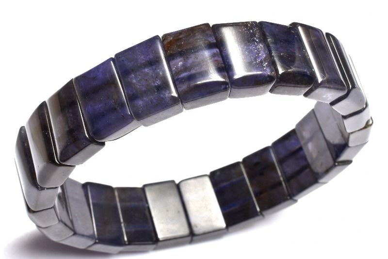 材質アイオライトサンストーン 8-8.5x13-14mm 産地：インドサイズ約8-8.5x13-14mm腕周り約17cm(伸縮性あり)重さ約35g特徴・意味高品質で透過性があり、アイオライト特有の多色性のカラーを堪能していただける逸品です。アベンチュレッセンスが共生しており、キラキラと輝きを放っています。多色性特有のブラウンカラーからパープルブルーカラーへの変化は夕暮れから夜にかけての空を閉じ込めたような幻想的な美しさがあります。アイオライトサンストーンは、アイオライトとサンストーンの両方の鉱物組成とエネルギー特性を持っていると、メロディ女史とシモンズ氏の著書の両方に記されています。アイオライト・サンストーンの素晴らしいエネルギーはシモンズ著「TheBookofStones」は以下のように記されています。「アイオライト・サンストーンはあなたが期待するとおり、アイオライトとサンストーンの特性を併せ持っています。それに加えて2つのマテリアルを合わせたシナジー効果によりいくつかの完全に新しいエネルギー効果を生み出します。アイオライトはインナービジョンの石で、サードアイを刺激し、サイキック能力や予言に関する才能を強化し、すべてのタイプの微細なエネルギーへの感受性を増加させます。この石は自己鍛錬の石でもあります。そしてあなたが自分の目的の達成のための具体的な計画を具現化させ続けるのを可能にします。サンストーンは、勇気とリーダーシップのヴァイブレーションを発します。それは困難な状況、あなたの精神的、たとえ身の危険があるとしてもグループ全体のためにその責任を取る生まれつき備わった能力を強化します。彼らの個々の特性に加え、アイオライト・サンストーンはビジョンのサードアイと、意志を行動へと変えるソーラプラクサスのエネルギーをひとつにします。【恋愛運】【金運・仕事運】BG::0000-SEP006008k