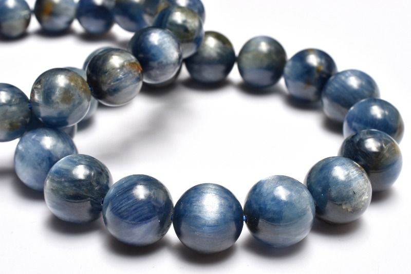 材質カイヤナイト 12mm 産地：ブラジルサイズ約12mm(±0.5mm)腕周り約16.5cm(伸縮性あり)重さ約57g特徴・意味近年カイヤナイトは染色した商品も多く流通している中でこのように無着色天然品はレアと言えます。繊維状のブルーカラーの結晶が何層にも重なっておりシラーを確認できる珠もございます。中にはヘマタイトと共生した珠もございますがお値打ちなアイテムとなっております。カイヤナイトは和名を藍晶石（らんしょうせき）と言います。カイヤナイトの中でも鮮やかで発色が良く、透明感を持つものほど高品質です。カイヤナイトをよく観察してみると、何本ものラインが見えますが、これは一定の方向に入った結晶が何重にも重なった層のように見えています。この層に対して、どの方向から力を与えるかによって硬度が変わってきます。この性質から二硬石（ディスシーン：Disthene）と呼ばれ、これにより、加工が大変難しくなっています。カイヤナイトの語源はギリシャ語で「青色」を意味する「kyanos」からきています。【金運・仕事運】【学業成就】BL::1112-N.A002004k