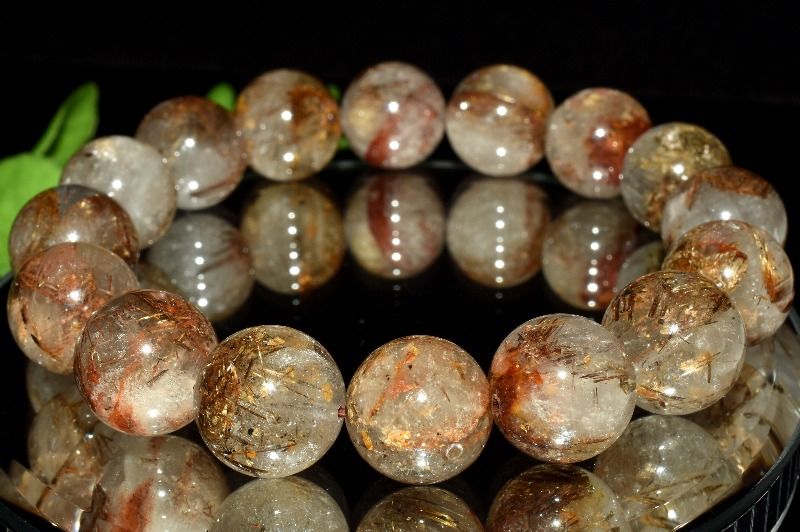 材質グリッドブロンズタイチンルチルクォーツ 13.5mm 産地：ブラジルサイズ約13.5mm(±0.5mm)腕周り約17cm(伸縮性あり)重さ約55g特徴・意味ミルキーな質感の水晶の中に、ブロンズカラーのタイチンルチルがグリッド状に広がる個性的なルチルクォーツです。さらに希少な雲母が共生することで、独特の輝きと奥行きのある表情を生み出しています。やわらかな白みを帯びた水晶と、金属的な光沢を持つルチルや雲母が重なり合い、一粒ごとに異なる景色を楽しめるのが魅力です。天然石ならではの個性と希少な共生関係を気軽に楽しめる一本です。ルチルクォーツは、和名で『金紅石入り水晶』と呼ばれます。ラテン語で『黄金色に輝く』という意味の言葉が語源です。ルチル（金紅石）は、その強い輝きで古くより人々に愛されてきたと伝えられています。そのルチルがクォーツに含まれたものを『ルチルクォーツ』、または『ルチルレイテッドクォーツ』と呼んでいます。ルチルがクォーツのパワーをいっそう高めるため、通常のクォーツよりも強力なエネルギーをもつといわれています。内部に『金色の線』が入っていることから『金銭』を呼び込むパワーストーンとされ、特に、黄金色に美しく輝くものは金運のお守りとして古くから珍重されてきました。【恋愛運】【人間関係】【金運・仕事運】【安産・子宝】BL::1314-N.A006008k