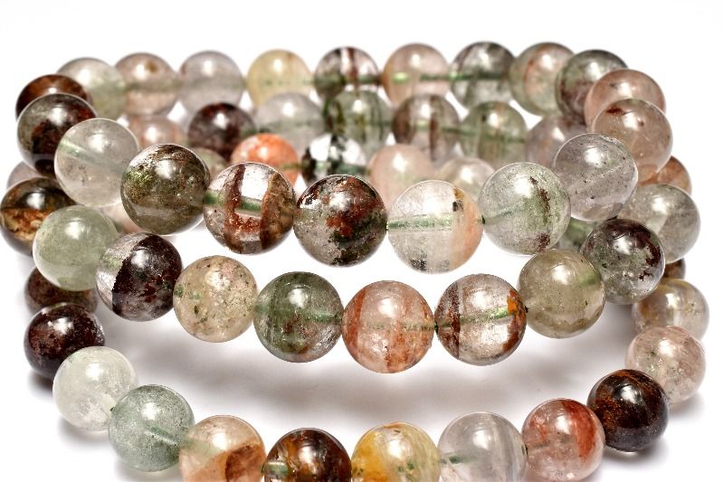 材質マルチカラー ガーデンクォーツ(庭園水晶) 産地：ブラジルサイズ約11.5mm（±0.5mm）腕周り約17cm(伸縮性有り)重さ約40g特徴・意味透明感のある水晶の中に浮かぶ幻想庭園！グリーンや褐色なと肌馴染みの良い落ち着いたカラーで一粒一粒違う景色にうっとりしてしまいそうです。浄化や癒しの石と言われる水晶の中でも、ガーデンクォーツは特にヒーリング効果が高いことで知られ、怒りや妬みなどのマイナス感情を和らげ、強い浄化作用があると言われています。 また正財運（ギャンブル性のない財運）を象徴する石で、同じく金運UPにオススメなルチルクォーツとの相性もいいです。中国で愛好されており、世界中にそのパワーが知られるようになりました。ガーデンクォーツは、水晶が形成される過程において、緑などの鉱物や泥岩、その他を巻き込み結晶した水晶です。その生成過程から出来上がった鉱石は、一つ一つ異なる模様（世界観）を持ち、水晶の中に自然の風景を収めたように見えるため、和名を「庭園水晶」または「苔入り水晶」と呼ぶこともあります。ガーデンクォーツといっても、多様な模様のため、種類は様々です。茶色の内包物、緑色の内包物、その両方を持つもの、ファントムと呼ばれる現象が見られるものもあります。