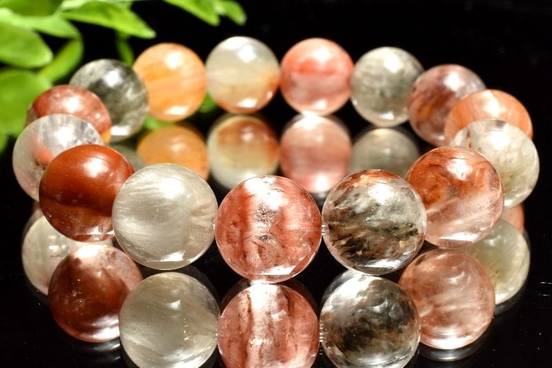 材質ラビットヘアールチルクォーツ 13.5mm 産地：ブラジルサイズ約13.5mm(±0.5mm)腕周り約16cm(伸縮性あり)重さ約55g特徴・意味多彩な色合いのラビットヘアールチルクォーツが織りなす、上品で華やかな印象のブレスレットです。アンフィボールインクォーツは、水晶（クォーツ）の中にアンフィボール（角閃石）が内包されたクリスタルです。ネフライトやアクチノライトなど角閃石を含有するクリスタルを始め、角閃石グループには180種を超える鉱物があるとされますが、このアンフィボールインクォーツもこの角閃石グループに属するクリスタルになります。色味は白色や透明のものが有名ですが、他に含まれる鉱物によって赤色、茶色、オレンジ色、黄色など様々な色味を見せてくれます。特に、ヘマタイトが含有されたアンフィボールインクォーツは燃えるような赤色に発色するため、良く知られている白色のアンフィボールインクォーツとは別物だと勘違いされる方もいるぐらいです。アンフィボールインクォーツは、内包されているアンフィボールによって羽のような、細い繊維のようなものが水晶の中に入っているように見えるクリスタルです。特に白色のものは、羽毛のような天使の翼のようなものにも見えることから、「エンジェルクォーツ」、「エンジェルファントムクォーツ」の名で呼ばれることもあります。