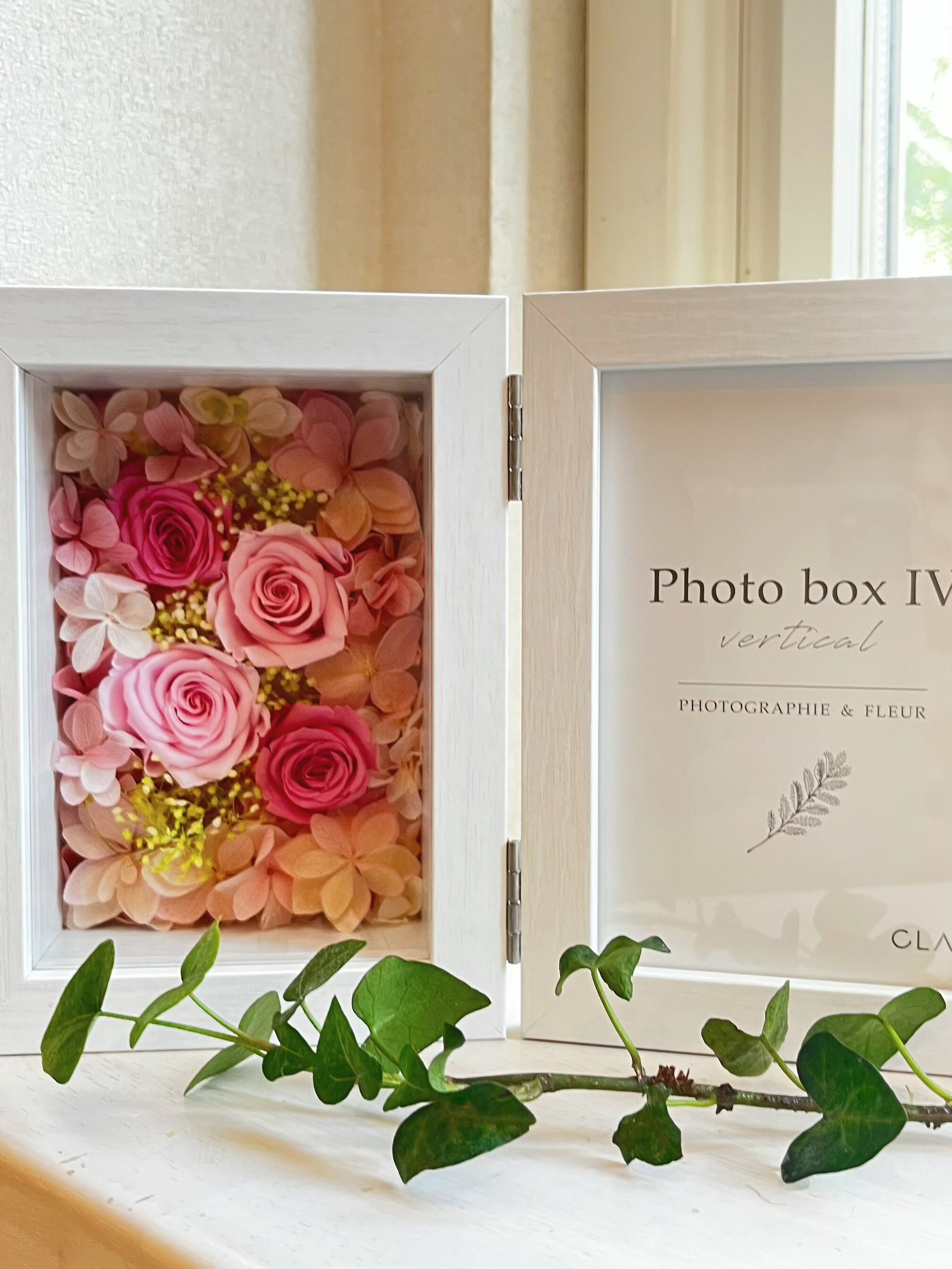 心落ち着く優しいピンクのバラのフォトフレームです。ひな紫陽花が可愛さプラス!! 特別な日の贈り物にぴったりで、幸せ感がいっぱい詰まっています。お誕生日や結婚祝い、出産祝い、母の日、敬老の日、クリスマス、退職、卒業など、さまざまなシーンで喜ばれること間違いなし。大切な思い出を彩るこのフォトフレームで、心温まる瞬間を演出してみませんか？ Lサイズの写真、はがきサイズの写真を入れられます。 ガラスカバー付きですので、ホコリの心配もなくお花も長く楽しめます。 使用花材:プリザーブドフラワー ( バラ　かすみ草　あじさい) フォトフレーム:MDF(木材)に紙貼りを施しており、水に弱いためお手入れの際には乾いた布をご使用下さい。 サイズ:広げた状態　横22 　奥行き6.5 高さ15センチ 写真 L判に対応 プリザーブドフラワーですので水をかけないで下さい。 縦置きフォトフレームこちらから大切な思い出をお花と共に〜