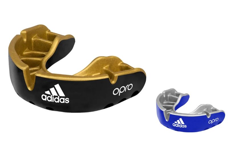 adidas マウスピース OPRO GOLD GEN4 マウスガード UFCの公式ライセンシーであるOPRO社とadidas社によるコラボマウスピース イングランドをはじめとした強豪国ラグビー協会のオフィシャルサプライヤーOPROのマウスピース イギリスの歯科医師によって、スポーツバイオメカニクスに基づいて製作した英国産のマウスガードです。 OPROフィンと呼ばれる「ヒダ」が付いております。 噛んで形を作る時に、ヒダが歯の間に入り込んで固定されるため、オーダー製品のように着け心地が良くなります。 また表面素材がシールドで覆われ、外からの衝撃やくいしばる力から歯を保護するとともに、脳障害予防や集中力の強化に役立ちます。 ラグビー・アメリカンフットボール・ラクロス・格闘技・ボクシングなどのコンタクトスポーツに加えて、バスケットボール・サッカー・陸上競技・野球など幅広い競技にご使用頂けます。