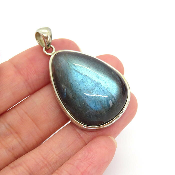 商品情報 天然石 ラブラドライト素材 シルバー925サイズ 約30×23×10mm （バチカン含まず）約12g付属品 ネックレスチェーン、ポーチ天然石製品について 天然石製品の特徴として天然由来の傷やくぼみ、内包物やクラック等が含まれることがあります。多少の天然由来のイメージ違い等による返品・交換は出来かねますことをご了承ください。備考 できる限り実際の商品の色合いに近づけておりますが、モニター環境の発色の具合により色合いが多少異なることがございます。【一点物】ラブラドライトAAAAA マダガスカル産 ペンダント ネックレス SV925 天然石 パワーストーン ブラックラブラドライト 曹灰長石 送料無料 チェーン付き ラブラドライト ペンダント ネックレス 天然石 パワーストーン シルバー925 アクセサリー ジュエリー ギフトラッピング無料 マダガスカル産のラブラドライトを使用したペンダントです。輝くブルーシラーが素晴らしい最高品質のラブラドライトです！こちらはベースの地色が濃く黒に近いので、より一層鮮やかに光り輝いて見られます。ラブラドライトに現れるこのシラーをラブラドレッセンスと呼びます。光の角度によって青や緑、虹色などに変化するレッセンスが非常に美しいお品です。ラブラドライトはムーンストーンと同じ長石のグループに属すことから、白いラブラドライトなど色合いによってはムーンストーンという総称が使われることもあります。ラブラドライトは宇宙や未来の知恵を伝える神秘のスピリチュアルストーンです。身につけると、高次元と繋がることができ、宇宙からのメッセージを受け取ることができるといわれます。持ち主の霊性を高め、精神のバランスを図る手助けをしてくれます。陽気になりすぎたときには冷静さを、気持ちがふさいだときには明るさを与えるなど感情をコントロールします。神経が研ぎ澄まされ、インスピレーションや集中力が増すので、何か新しいことを始める時やクリエイティブな仕事をされている方にもおすすめです。※こちらの商品は一点物です。画像は現物を撮影しております。 2