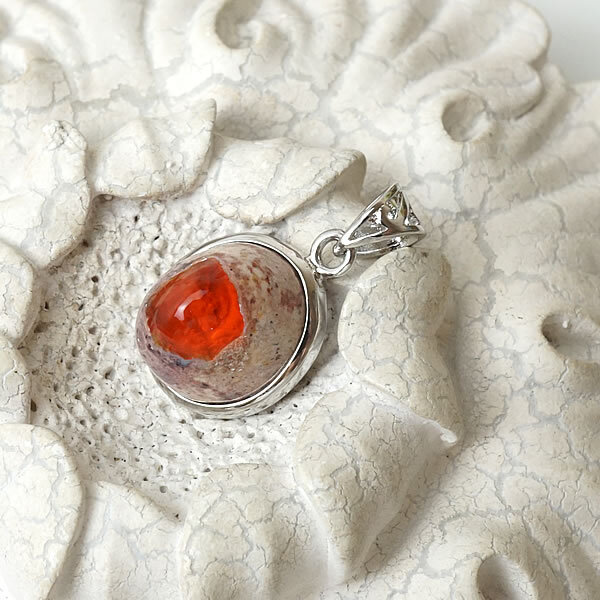 商品情報天然石ファイアオパール素材シルバー925サイズ約15×13×10mm （バチカン含まず）約3g付属品ネックレスチェーン、ポーチ天然石製品について天然石製品の特徴として天然由来の傷やくぼみ、内包物やクラック等が含まれることがあります。多少の天然由来のイメージ違い等による返品・交換は出来かねますことをご了承ください。備考できる限り実際の商品の色合いに近づけておりますが、モニター環境の発色の具合により色合いが多少異なることがございます。【一点物/希少】ファイアオパールAAAAA メキシコ産 カンテラオパール ペンダント ネックレス 天然石 パワーストーン アクセサリー オパール ファイヤーオパール チェーン付き 送料無料 ペンダント ネックレス 天然石 パワーストーン シルバー925 アクセサリー ジュエリー ステンレスチェーン ギフトラッピング無料 メキシコ産の希少なファイアオパールをペンダントに仕立てたお品です。メキシコ産のファイアオパールは「カンテラオパール」とも呼ばれ、情熱的な炎を思わせる明るいオレンジ色の遊色が最大の特徴です。流通量が非常に少なく、大変高価で貴重な宝石として知られます。オパールは幸福の石です。オパールは太陽のような明るさとポジティブで肯定的なエネルギーに満ちており、身につけると人生に情熱をもたらすといわれます。積極性と行動力を与え、何かにチャレンジする人を助けます。恋愛においても情熱的な出会いを授け、自信と積極的な行動を手助けしてくれます。※こちらの商品は一点物です。写真は現物を撮影しております。 2