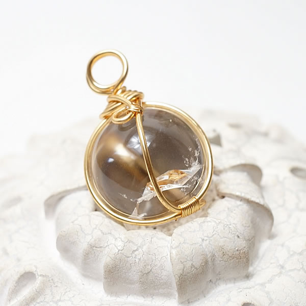 商品情報天然石アイリスクォーツ（レインボー水晶）素材シルバー925ワイヤー(ゴールドカラー)サイズ約20mm （バチカン含まず）約12g付属品ネックレスチェーン、ポーチ天然石製品について天然石製品の特徴として天然由来の傷やくぼみ、内包物やクラック等が含まれることがあります。多少の天然由来のイメージ違い等による返品・交換は出来かねますことをご了承ください。備考できる限り実際の商品の色合いに近づけておりますが、モニター環境の発色の具合により色合いが多少異なることがございます。【一点物】アイリスクォーツ レインボー水晶AAAAA ブラジル産 虹り水晶 レインボークォーツ ペンダント ネックレス ゴールドカラー 天然石 パワーストーン 4月の誕生石 幸運 開運 レインボー水晶 アイリスクォーツ 虹り水晶 レインボークォーツ チェーン付き ペンダント ネックレス 天然石 パワーストーン シルバー925 アクセサリー ジュエリー ギフトラッピング ブラジル産のアイリスクォーツ(通称レインボー水晶)のペンダントです。20ミリのラウンド球をワイヤー巻きでペンダントに仕立てた存在感のあるお品です。レインボー水晶は水晶の成長過程で自然に出来る亀裂が放つ光が美しい虹色を生み出したものになり、虹色水晶とも呼ばれています。レインボー水晶は幸運のパワーストーンとして知られます。チャンスや希望を与え、持ち主を至る所から輝かせ明るい未来を授けます。※こちらの商品は一点物です。画像は現物を撮影しております。 2