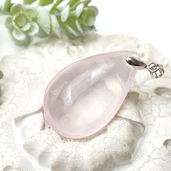 商品情報天然石ローズクォーツ素材シルバー925サイズ約35x22x12mm （バチカン含まず）約13g付属品ネックレスチェーン、ポーチ天然石製品について天然石製品の特徴として天然由来の傷やくぼみ、内包物やクラック等が含まれることがあります。多少の天然由来のイメージ違い等による返品・交換は出来かねますことをご了承ください。備考できる限り実際の商品の色合いに近づけておりますが、モニター環境の発色の具合により色合いが多少異なることがございます。【一点物/最上級】ローズクォーツAAAAA マダガスカル産 ペンダント ネックレス ドロップ型 天然石 パワーストーン SV925 紅水晶 宝石質 チェーン付き 送料無料 ローズクォーツ ペンダント ネックレス 天然石 パワーストーン シルバー925 アクセサリー ジュエリー ギフトラッピング無料 マダガスカル産のローズクォーツを使用したペンダントです。ぷっくり可愛らしいピンク色に透明感の素晴らしい最上級品質のローズクォーツです。ローズクォーツは和名で『紅水晶』と呼ばれるの水晶の一種です。可愛らしいピンク色で女性に人気の石です。ローズクォーツは恋愛の石として有名です。愛と美の女神アフロディーテの石といわれ、愛と美を司る石です。恋愛成就や幸福な結婚を叶えるだけでなく、失恋などで傷付いた心を癒す効果もあるといわれています。持ち主の魅力を引き出し、内外両方の美しさを高めるといわれます。ローズクォーツは慈愛を育てる石でもあります。自分自身や他人を心から愛せないと感じる時、ローズクォーツは母のようなやさしさと深い愛情を抱かせ、今ある存在の大切さを感じさせてくれます。女性だけでなく、愛情不足の男性にも効果的だといわれています。 2