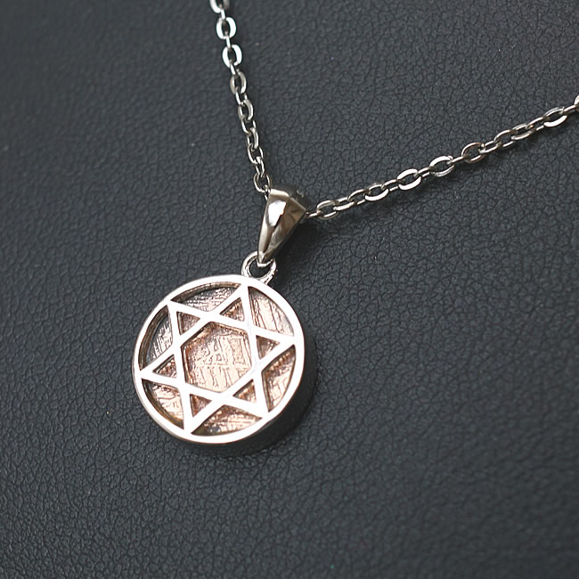 商品情報天然石ギベオン隕石（メテオライト）ピンクゴールドカラー素材シルバー925・ロジウムコーティングサイズ約13×13×3mm （バチカン含まず）付属品ネックレスチェーン、ポーチ天然石製品について天然石製品の特徴として天然由来の傷やくぼみ、内包物やクラック等が含まれることがあります。多少の天然由来のイメージ違い等による返品・交換は出来かねますことをご了承ください。備考できる限り実際の商品の色合いに近づけておりますが、モニター環境の発色の具合により色合いが多少異なることがございます。ギベオン隕石 メテオライト ピンクゴールド 六芒星 ヘキサゴン ペンダント ネックレス 天然石 パワーストーン 隕石 隕鉄 鉄隕石 ヘキサグラム リバーシブル 両面仕上げ チェーン付き メテオライト 六芒星 ヘキサゴン ギベオン隕石 隕石 鉄隕石 ペンダント ネックレス 天然石 パワーストーン シルバー925 SV925 アクセサリー ステンレスチェーン ジュエリー ギベオン隕石（メテオライト）のペンダントです。神秘の図形といわれる六芒星型がシンボルのデザインです。六芒星はエネルギーの調和を促す形として、お守りには最適です。【ギベオン隕石とは？】ギベオン隕石は、1836年ナミビア砂漠で発見された鉄隕石の一つで、主に鉄とニッケルから形成されている物質です。これは地球上では再現することが不可能と言われ、成分的にも地球上には存在しない物質が極微量、含まれているといわれます。【ギベオン隕石の特徴】表面に網目状のウィドマンシュテッテン構造と呼ばれる模様がはっきりと見られます。これはギベオンだけが持つ最大の特徴です。【ギベオン隕石の石言葉】ギベオン隕石には宇宙からのメッセージが刻みこまれているとされ、ギベオンを手にした全ての人達は宇宙からの奇跡の力を知る事になるといわれています。持つ人の願いを叶え、夢の達成へとサポートするといわれます。 2