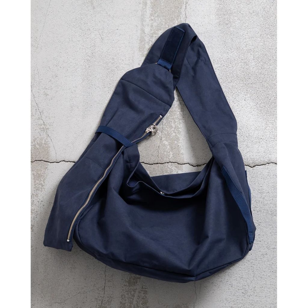 ,,,,,,,,,yorozu NITEN TASUKI SHOULDER "HIGH DENSITY MICROFIBER"(NAVY)〈ヨロズ〉yorozuNITEN TASUKI SHOULDER "HIGH DENSITY MICROFIBER"・三つの持ち方を切り替えられる、機動性の高いタスキショルダーです。・高密度マイクロファイバースエードの肌触りが心地よいです。・可動式ショルダーと複数の収納により、日常の移動からアクティブな場面まで対応します。静けさと、機動性。相反するようでいて、どちらも妥協しないためのタスキショルダーです。左右どちらからも掛けられる設計。ショルダーを本体に固定するベーシックなスタイル。身体の動きに合わせてショルダーが可動するスタイル。アクティブな場面では、ショルダーを身体脇に固定するスタイル。状況に応じて、三つの持ち方を切り替えられます。可動するショルダー部分にはファスナーを配置。デザインのアクセントであると同時に、収納としても機能します。ポケットは合計5。内装前面には、鍵などを取り付けられるテープ付きDカンを備えています。ショルダーの長さはワンタッチで調節可能。動きの流れを止めません。高密度マイクロファイバースエードを使用した、タスキショルダー。しっとりとなめらかな質感と、ほどよいふくらみのある素材感が、装いにやわらかな奥行きを添えます。日常の中で気負わず使える軽やかさも感じられる素材です。付属レザーには、日本製のヌバックレザーを使用。アイテム名とその構造は、宮本武蔵の号、そして弟子たちが伝えた「二天道無二」「二天一流」に着想を得ています。二つでありながら、一つであること。静と動を行き来するためのかたちです。サイズ幅：46cm高さ：32cm奥行き：16.5cm生産国日本製【当店の商品について】お客様に自信を持って、おすすめできる商品のみ取り扱っております。 日本製のものやインポートブランドを中心にアメカジ、ストリート、キレイめ、アウトドア、スポーツ、シルバーアクセサリー、スニーカーや帽子など幅広いセレクトにて展開しております。ランキング上位商品、人気商品、お得な訳ありアウトレット商品、お買い得な値引き・割引き・セール商品、ポイント変倍商品はお問い合わせが多く、 数に限りがありますので、お早目にお買い求めください。【以下のような方に多くご利用いただいております。】様々な商品を取り揃えている為、20代 30代 40代 50代 60代の方にご利用頂いております。 メンズブランドが多いですがユニセックスで着用できる商品を意識してセレクトしております。アクセサリーは、ギフトで御購入頂くお客様も非常に多いです。シンプルなものデザイン性の高いもの、若い世代向けのデザインなど、豊富に取り揃えておりますので、ぜひごゆっくりお買い物をお楽しみくださいませ。2