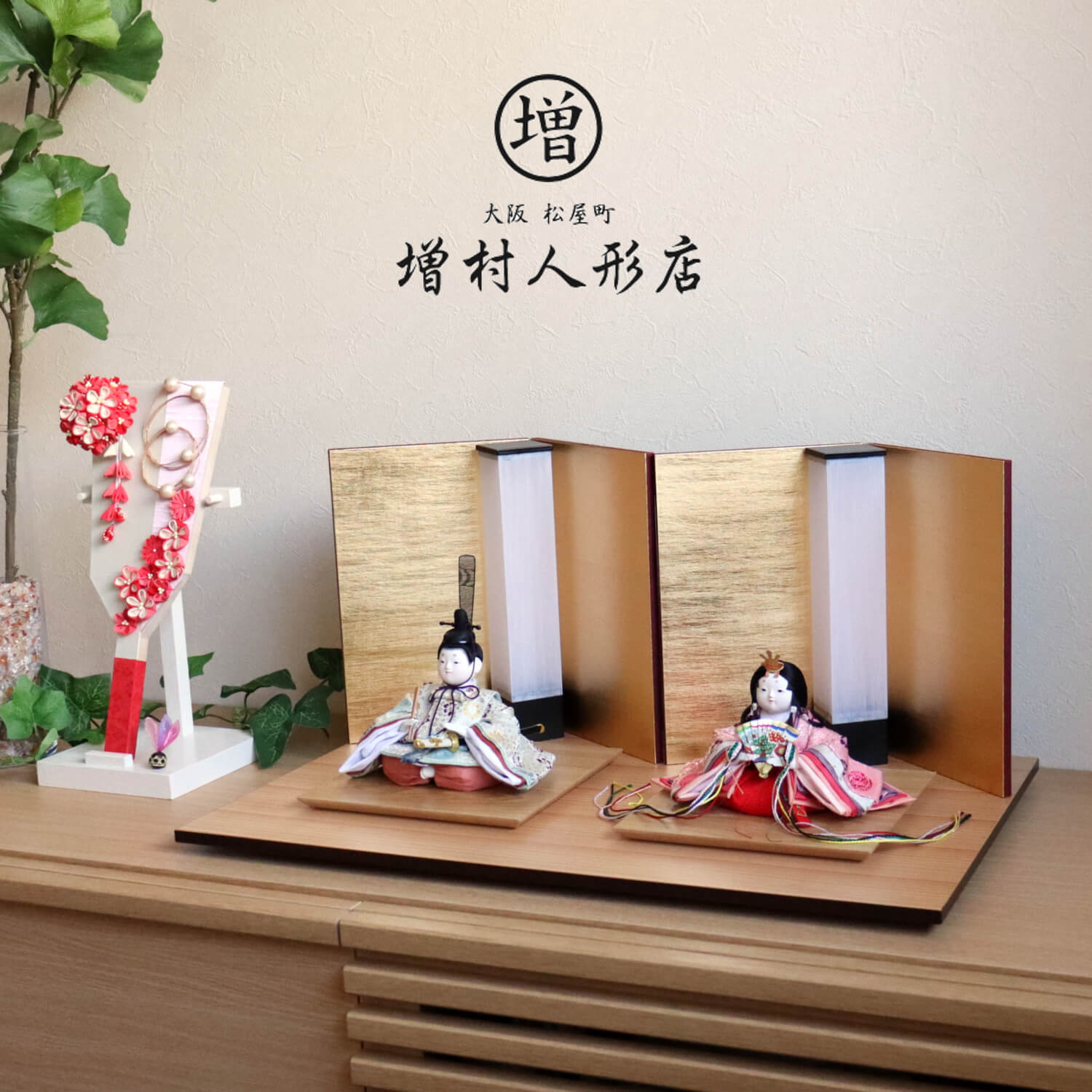 ※こちらの別売りの羽子板は、当ショップが販売致しております「羽子板　赤ピンク」をご参照ください。 サイズ 幅 55cm × 奥行 33cm × 高さ 26cm こころに寄り添う人形創りに受け継がれる技術と心 幸一光は、100年以上の歴史を持つ伝統的工芸品「江戸木目込人形」「江戸節句人形」という二つの技術を継承し「ひな人形」と「五月人形」の両方を手掛けるエ房です。 70代の熟練職人から20代の若手職人まで、幅広い年代の職人が日々技術を磨き、次の世代に技と心を伝えております。 《　三代目 幸一光　》 大正九年、東京の下町下谷竹町に創業し、以来九十有余年に亘り人形製造に携わる。 現三代目松崎幸一光は、昭和28年に東京で生まれ、昭和46年に18歳で父である先代、松崎幸雄(二代目昭玉)に師事。昭和63年には京都府立文化博物館に平治物語絵巻の信西の巻を基に武者行列を製作。 平成9年には重要無形文化財保持者(人間国宝)平田郷陽の弟子である芹川英子に師事。 平成12年には数々の功績が認められ、経済産業大臣認定伝統工芸士認定。続く平成17年には東京都知事認定東京マイスターに選ばれる。 現在に至るまで、総理大臣賞、最優秀技能賞を始め数々の受賞歴を有する、江戸木目込界を代表する作家の一人。 京都西陣織「大嶋金襴(おおしまきんらん)」 最高級正絹西陣織に特化した金襴商。昭和58年、実父である大嶋喬が1800年代後半より続く京都の老舗金襴卸問屋で約30年勤めた後に独立し「大嶋金襴」を設立。現代表の大嶋浩之は二代目。その納品先は著名人形職人のみならず、本山級神社仏閣、人間国宝級刀匠など多岐に渡る。本金や手織をはじめとする最高級正絹西陣織に特化した金襴商。※こちらの別売りの羽子板は、当ショップが販売致しております「羽子板　赤ピンク」をご参照ください。 サイズ 幅 55cm × 奥行 33cm × 高さ 26cm こころに寄り添う人形創りに受け継がれる技術と心 幸一光は、100年以上の歴史を持つ伝統的工芸品「江戸木目込人形」「江戸節句人形」という二つの技術を継承し「ひな人形」と「五月人形」の両方を手掛けるエ房です。 70代の熟練職人から20代の若手職人まで、幅広い年代の職人が日々技術を磨き、次の世代に技と心を伝えております。 《　三代目 幸一光　》 大正九年、東京の下町下谷竹町に創業し、以来九十有余年に亘り人形製造に携わる。 現三代目松崎幸一光は、昭和28年に東京で生まれ、昭和46年に18歳で父である先代、松崎幸雄(二代目昭玉)に師事。昭和63年には京都府立文化博物館に平治物語絵巻の信西の巻を基に武者行列を製作。 平成9年には重要無形文化財保持者(人間国宝)平田郷陽の弟子である芹川英子に師事。 平成12年には数々の功績が認められ、経済産業大臣認定伝統工芸士認定。続く平成17年には東京都知事認定東京マイスターに選ばれる。 現在に至るまで、総理大臣賞、最優秀技能賞を始め数々の受賞歴を有する、江戸木目込界を代表する作家の一人。 京都西陣織「大嶋金襴(おおしまきんらん)」 最高級正絹西陣織に特化した金襴商。昭和58年、実父である大嶋喬が1800年代後半より続く京都の老舗金襴卸問屋で約30年勤めた後に独立し「大嶋金襴」を設立。現代表の大嶋浩之は二代目。その納品先は著名人形職人のみならず、本山級神社仏閣、人間国宝級刀匠など多岐に渡る。本金や手織をはじめとする最高級正絹西陣織に特化した金襴商。