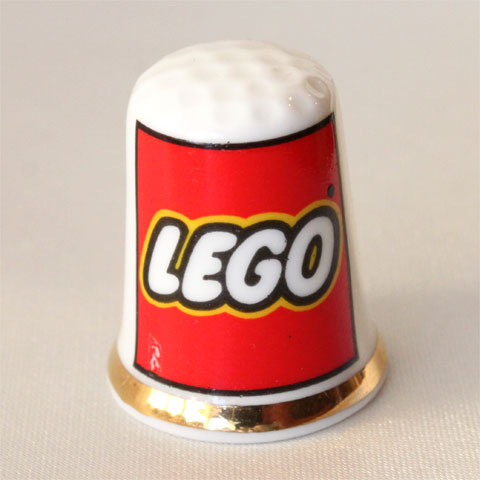 Advertising Thimble LEGO 1934年設立、「よく遊べ」を意味するデンマーク語 "Leg Godt"から社名をLEGOとした デンマークの玩具メーカー レゴブロック 正面左下に少しプリントのハゲがあります。 イギリス　 磁器製 サイズ：約23x23x28mm