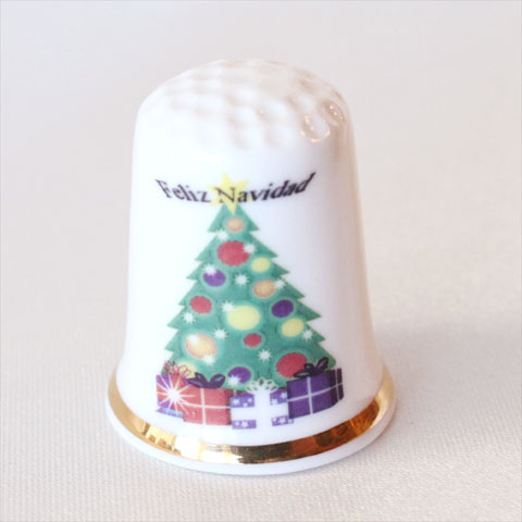 クリスマス・シンブル クリスマスシーンを彩る 小さなシンブル。 あなたの素敵なシンブル・コレクションが、 とっておきのクリスマス・ディスプレイ♪ スペイン Feliz Navidad　（フェリス　ナヴィダ） （＝メリークリスマス） 年末年始のあいさつの文字と モミの木とプレゼントのデザイン イギリス ボーンチャイナ サイズ：約22x22x28mm