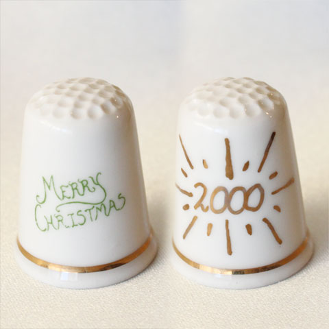 Christmas Thimble 「クリスマス2000」 Merry Christmasの文字と 対面にゴールドで2000のデザイン。 2000年、ミレニアムの年のクリスマスに限定発行。 イギリスで多くのシンブルを紹介、 自らもオリジナルシンブルを発行している シンブルギルドの限定発行シンブル。 イギリス　シンブルギルド ファインボーンチャイナ サイズ：約23x23x28mm