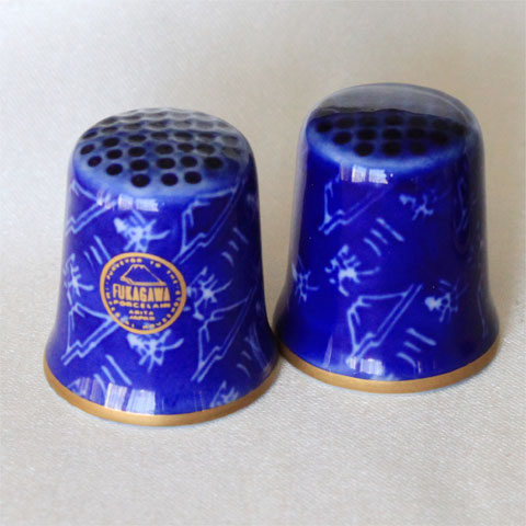 Fukagawa　Hallmark thimble 普通なら、食器の裏でひっそりとしながらも 製品の歴史をひもとく鍵となるファクトリーマーク。 そのマークをデザインにして作られたのがこのシンブルです。 現在は生産されていない、貴重な品です。 日本　深川 磁器 サイズ：約22x22x26mmThe Hallmarked Thimbles of the World's Great Porcelain Houses　 ＝世界の名窯　ホールマーク（窯のマーク）シンブル＝ シンブル・コレクターズ・クラブ（TCC）より1985年に会員向けに限定発売。 全50種の窯(ファクトリー)のマークをデザインしたシンブル。 入手の難しい名窯ばかりのシリーズです。 Fukagawa　＝深川＝ 日本で1800年代から続く磁器メーカー 初代の深川忠次は1900年パリ万国博覧会で金賞を受賞、世界に広く有田様式を広める。 日本の技術力の高さと感じられる素晴らしい品です。