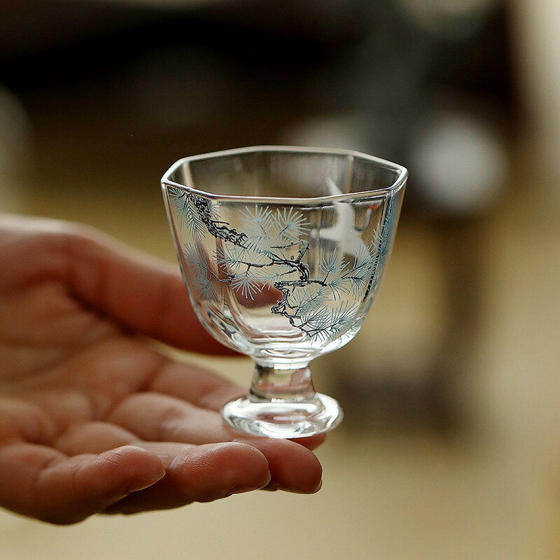 耐熱ガラス茶杯 八角形高台 松鶴浮彫り 日常の茶席や来客時に活躍する、八角形の高台付きガラス茶杯です。 ホウケイ酸ガラス製で急な温度変化にも強く、約50mlのコンパクトな容量はお茶はもちろん、晩酌のぐい呑みとしても使いやすいサイズです。杯身に施された松と鶴の浮彫りが、透明なガラスにさりげない趣を添えます。 シンプルでモダンな佇まいが、茶器としても酒杯としてもテーブルを上品に演出します。 ■ 商品の特徴 ホウケイ酸ガラス素材で、約-20℃から150℃の急激な温度差にも耐え、割れにくい設計です。 八角形の杯身と高台の組み合わせにより、見た目に安定感があり持ちやすい形状です。 杯身に松と鶴の浮彫り模様を施し、透明なガラスに繊細な表情を与えています。 容量約50mlのコンパクトサイズで、品茗や小酌に適した使いやすい容量です。 口径約5.6cm、高さ約5.8cmの手頃なサイズで、茶席やデスクにも置きやすいです。 お茶だけでなく、清酒などのぐい呑み・お猪口としてもお使いいただけます。 シンプルでモダンなデザインが、日常使いから来客時まで幅広く活躍します。 ■ カラー ハッポウ カップ ■ 仕様 サイズ口径約5.6cm、高さ約5.8cm 容量約50ml セット内容茶杯本体1点 対象男女兼用 用途お茶・茶席・ぐい呑み 素材ホウケイ酸ガラス 形状八角形・高台付き 模様松鶴浮彫り ■ おすすめシーン 居家での日常の品茶に 茶席や来客時のもてなしに 清酒や晩酌のぐい呑みとして デスクやテーブルの茶器として 茶空間やインテリアのディスプレイに 新生活やギフトの贈り物に ※サイズは手作業による採寸のため、多少の誤差がある場合がございます。※モニター環境により実物と色味が異なる場合がございます。※柔らかいスポンジと中性洗剤で優しく洗ってください。金属たわしや研磨剤は使用しないでください。※破損防止のため丁寧にお取り扱いください。