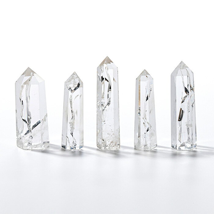 アイリスクォーツ（Iris Quartz）は、レインボー水晶（Rainbow Quartz）とも呼ばれる水晶の一種で、光の干渉現象により内部に虹色の輝きが現れるのが特徴です。「Iris（アイリス）」という名前は、ギリシャ神話に登場する虹の女神イリスに由来しており、その輝きが虹のように見えることから名付けられています。アイリスクォーツの最大の特徴は、光の当たり方によって現れる虹色の反射です。この虹は、石の内部のクラック（地球の地殻活動や成長過程で自然に生じた亀裂）や内包物に光が反射・屈折してできるもので、自然現象の産物であり、人工的に加工されたものではありません。そのため、一つ一つ異なる虹色の模様を持っています。虹色は見る角度によって変化し、まるで万華鏡のような美しい光のパターンを楽しむことができます。アイリスクォーツはスピリチュアルな意味でも人気があり、内部に虹を持つことから、自分自身の内面を見つめ、内的な成長や洞察をサポートする石とされています。また、虹の輝きが希望の象徴とされ、持つ人に前向きなエネルギーと癒しを与えると考えられています。水晶の基本的な性質である「浄化」の力に加え、虹の光が心を明るく照らし、持ち主にポジティブな影響を与えると信じられています。アイリスクォーツの水晶ポイント5本組です。地鎮水晶や結界水晶としてもお使い頂けます。やや大きめの水晶ポイントを家や敷地の中央に、4本揃ったポイントを家や敷地の四隅に配してください。アイデア次第でいろいろな用途でお使いいただけます。結界水晶（地鎮水晶）の使用方法◆地鎮めを行う土地の中心にやや大きめの水晶を一つ、四隅にはやや小さめの水晶を一つずつ合計五個の水晶を配します。中央の水晶は浅く埋め、四隅は深く埋めます。◆すでに建物が建っている場合には、同様に建物内の四隅と 中心に水晶を配します。中心のやや大きめの水晶は、少し高くなるように配してください。◆部屋の地鎮めを行うことも可能です。先ほどと同様に水晶を配してください。◆その他、お店、倉庫、蔵、書斎やデスク廻り等々、気になる所にご利用頂けます。水晶が長い年月、人々を守り続け、土地を浄化します。■サイズ（約・mm）17&times;14&times;61 〜 18&times;15&times;71■重量（約・g）158■材質天然石（天然水晶（アイリスクォーツ））■お手入れの方法クラスター、ホワイトセージ、音叉、太陽光、月光、浴水が良いといわれています。■替え時・処分の方法浄化後お塩で清め、不燃物として処分してください。こちらの商品は一点もので、店頭でも販売いたしております。在庫状況はすぐ反映するよう努めておりますが、売切れの場合はご容赦ください。商品写真の色合いは、お客様がお使いの情報端末デバイスの環境により若干異なって見える場合がございます。水晶 ポイント レインボークォーツ レインボークオーツ アイリスクォーツ アイリスクオーツ クリスタル 天然水晶 結界 地鎮 浄化 パワーストーン 天然石