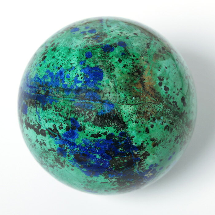 ※商品のすり替え防止の為に返品はお受けできかねます。クリソコラ（Chrysocolla）は、銅を含む鉱物で、美しい青や緑の色合いが特徴です。酸化銅鉱床でマラカイト（孔雀石）やアズライト（藍銅鉱）、クォーツ（石英）などと共に産出し、非晶質のため柔らかく、繊細な輝きを持ちます。その鮮やかな色彩から宝石や装飾品として人気があります。クリソコラの名前は、ギリシャ語の「chrysos（金）」と「kolla（接着剤）」に由来します。この名前がつけられたのは、古代にクリソコラが金のろう付け（はんだ付け）の際の接着剤として使われていたことに由来しています。紀元前の時代、鉱石の精錬や金属加工の際に使用されたことが記録されています。クリソコラはその美しい青緑色が特徴ですが、鉱物名の由来はその見た目ではなく、古代の金属加工技術に関係する用途から来ているのが興味深い点です。クリソコラは「癒しと調和の石」として知られ、穏やかなエネルギーを持つパワーストーンです。美しい青緑色は、海や大地を思わせ、心を落ち着かせる効果があるとされています。特にコミュニケーション能力を高める力があるとされ、対人関係を円滑にしたい人や、自己表現力を向上させたい人におすすめと言われています。また、芸術的なインスピレーションや創造力を高めるともされ、アーティストやクリエイターにも人気があります。古代エジプトでは、女王クレオパトラがクリソコラを愛用していたと伝えられています。この石は女性の内面の美しさを引き出し、自信を高めるとも言われています。※玉置き台は別売りです。■サイズ（約・mm）径72■重量（約・g）430■材質天然石（クリソコラ）■お手入れの方法クラスター、ホワイトセージ、音叉、月光が良いと言われています。■替え時・処分の方法浄化後お塩で清め、不燃物として処分してください。こちらの商品は一点もので、店頭でも販売いたしております。在庫状況はすぐ反映するよう努めておりますが、売切れの場合はご容赦ください。商品写真の色合いは、お客様がお使いの情報端末デバイスの環境により若干異なって見える場合がございます。クリソコラ 丸玉 珪孔雀石 chrysocolla クリソコラシリカ シリシファイドクリソコラ パワーストーン 天然石