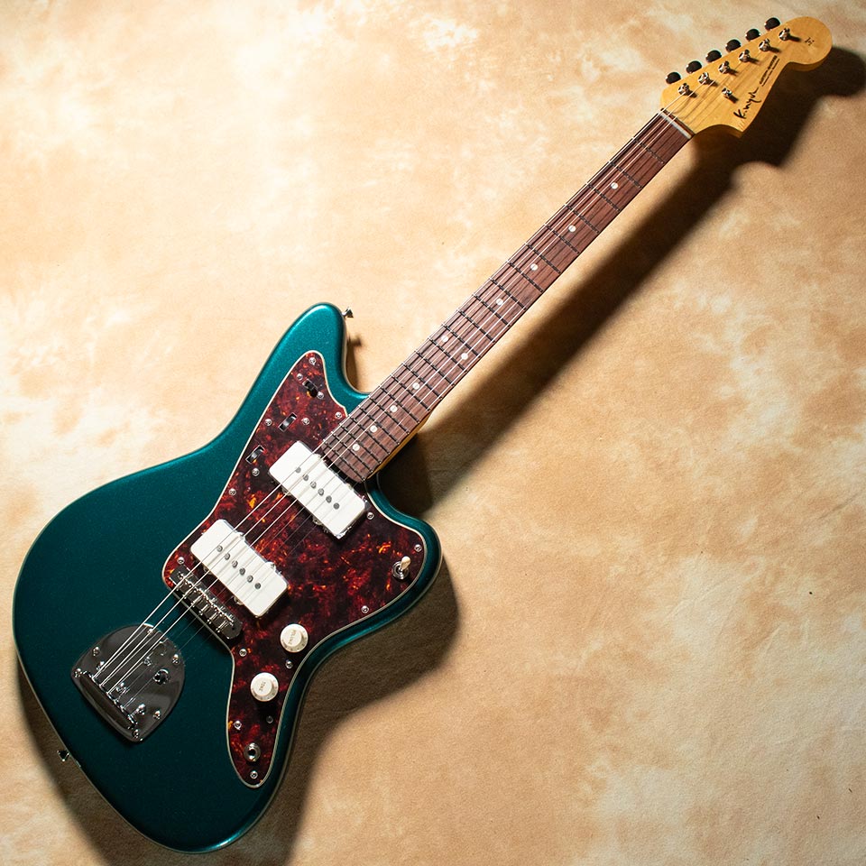 PGMが誇るマスタービルダー乳井氏のブランドK.Nyui Custom Guitarsから「KNJM」が入荷！ ここを読んでくださっている方、まず見た目でグッときた方が多いのではないでしょうか。 Sherwood Greenというあまり王道ではないカラーに対し鼈甲のPG、 確かにどこかで見たこともある気しますが、オーダー時には思いつきづらい組み合わせです。 このカラーはすごく深みを感させてくれます。 木材はボディにアルダー、メイプルネックにマダガスカルローズウッド指板、 奇を衒うことのない標準的な構成です。 しかしこの標準的な構成で標準以上のサウンドを叩き出してしまうのがK.Nyuiの素晴らしいところですね。 ピックアップにはLollar 58 JMを採用 「パーカッシブなローエンドとクリアで明瞭なトップエンド」 と説明される通り非常にタイトなサウンドです。 センターボジションでの特に引き締まったサウンドはまさに「ジャスマスター」のサウンド！ ジャキっとカッティングをしてもよし、タイトなロー感を活かして巻き弦でのリフを弾くもよし！ 弾いているだけで色んなプレイへのインスピレーションが無限に湧き上がってきます。 もちろん中音域やトーンを絞った際のメロウなサウンドはさすがジャズマスターです。 タイトで引き締ったと言えどしっかりと太いサウンドを出力してくれます。 ジャズマスタータイプがお好きなお客様にも、初めて触れる方にも、 「これぞジャズマスタータイプ」です。 ぜひご試奏にいらっしゃってくださいね。 SPEC Body : Alder Neck : Maple Fingerboard : Madagascar Rosewood (210R) Fret : Jescar #FW55090 Tuner : Gotoh SD91-05M Bridge : JM Type PU : Lollar 58 JM 3.4kg ※K.Nyuiは非常に薄く繊細な塗装が特徴となっております。 製造時や試奏時などについた細かな傷などが見受けられる場合がございますが、商品の特徴としてご理解くださいませ。