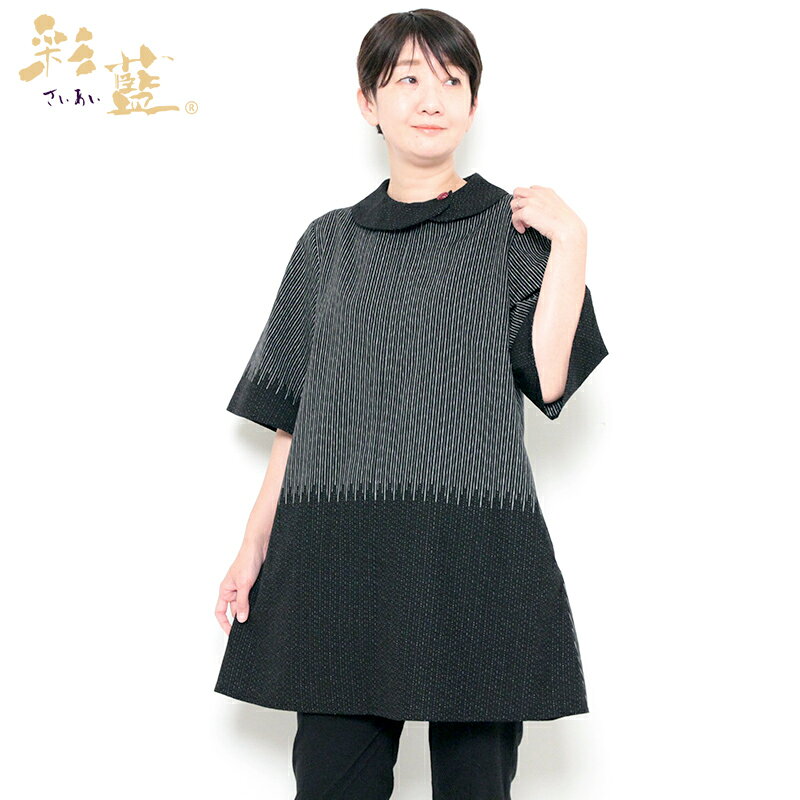 彩藍 夜空（よぞら）チュニック 五分袖 黒のみ 26601 揺らぎのある縞の織柄をシックに装う 夜空に煌めく星が流れる情景を繊細に表現した和木綿「夜空」を使用した爽やかな五分袖チュニックができました。 布地の柄を活かした、存在感のある一枚。 後ろ身頃は、前身頃の向きを上下反転させたこだわりのあるデザインです。 襟に配した久留米絣の赤いボタンがポイント。 ボタンを外すと内側のファスナーで大きく開くた