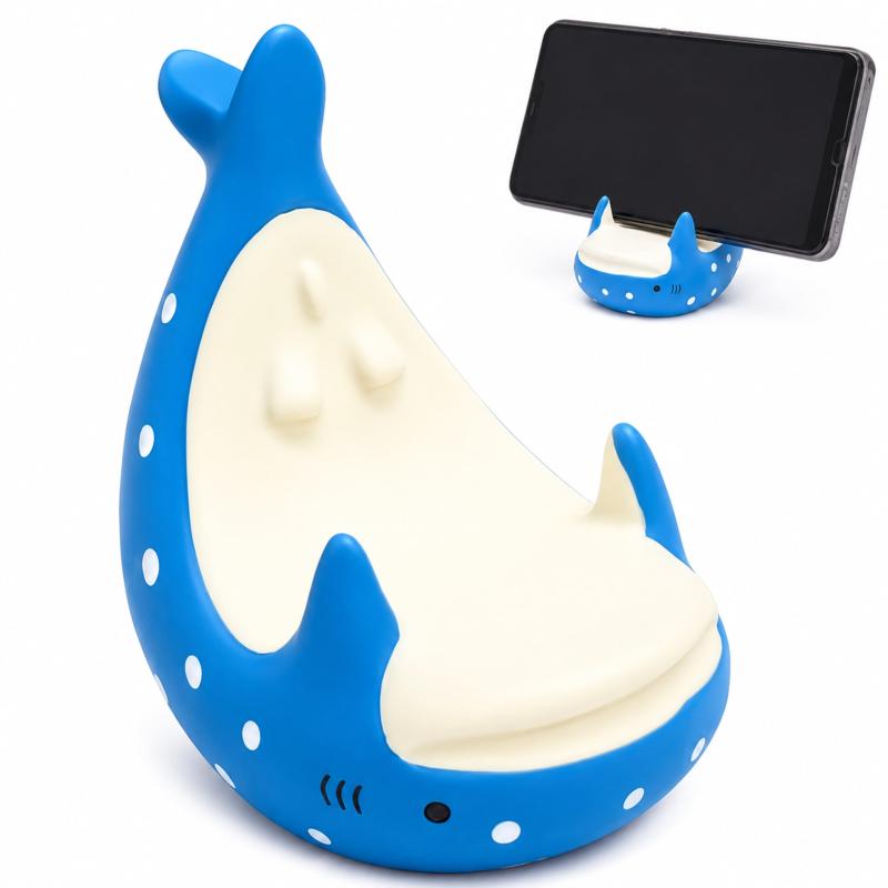CIOP ジンベエザメ スマホスタンド おしゃれ かわいい 卓上 スマホ置き 安定 滑り止め デスク インテリア プレゼント ギフト 海 動物 癒し【置くだけで癒される存在感】やさしいフォルムのジンベエザメが、デスクに癒しをプラス。見るたびにほっとするデザインです。【スマホをしっかり支える安定設計】しっかりとした重心バランスで、スマホを安定して固定。倒れにくく安心して使えます。【充電しながら使える設計】充電ケーブルを差したまま設置可能。動画視聴や作業中にも便利です。【デスクが整う定位置化】「とりあえず置き」がなくなり、スマホの定位置が決まる。机がスッキリ整います。【プレゼントにも最適】海や動物が好きな方へ。ちょっとしたギフトにも喜ばれるアイテムです。