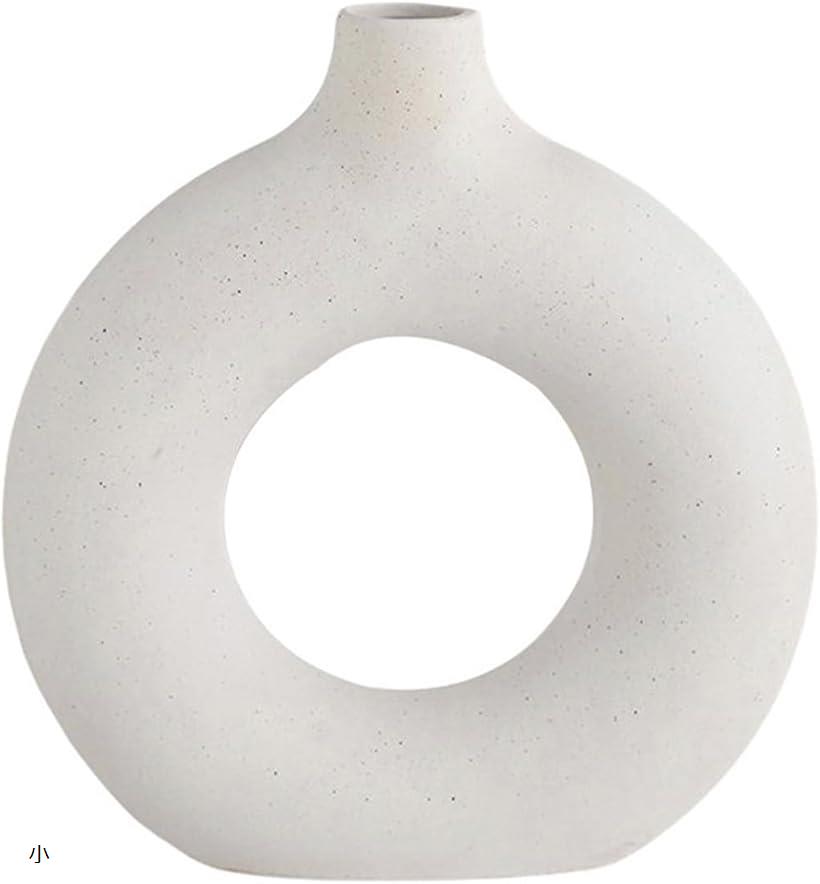 現代の家に溶け込む、ユニークな形状のセラミック花瓶です。穏やかな色合いと滑らかな曲線が特徴で、単独でも生花を添えても美しく映えます。実用性と芸術性を兼ね備えたインテリアアイテム。サイズ：(小)高さ14.3x横幅13.3x奥行2.5cm　(中...