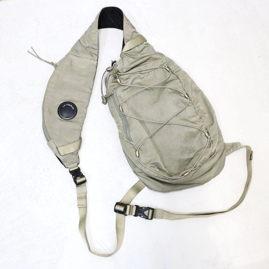 ■DESCRIPTION■【C.P. COMPANY国内正規取扱店】ミリタリー風の光沢あるナイロンサテン「Nylon B」を使用したクロスボディリュックサック。バックル留めの調節可能なストラップ、背面のジッパーポケットとマジックテープポケット、ジッパーポケット、そしてロゴをあしらった内側のスナップボタン付きポケットを備えています。このアイテムはガーメントダイ加工が施されており、独特の色合いを実現し、使い込むにつれてその色合いが深まります。このアイテムのレンズは、新しいマット仕上げのデザインを採用しており、2026年Fall/Winterコレクションから導入されたNFC (近距離無線通信) 技術が組み込まれています。スマートフォンでタップするだけで「プロダクト・パスポート」が開き、そのアイテムに関する情報にアクセスできます。また、内側のラベルにあるQRコードをスキャンしても「プロダクト・パスポート」にアクセスできます。 バックル留め付き調節可能ストラップ 背面ジッパーポケットおよびマジックテープポケット ジッパーポケット レンズディテール ロゴディテール付き内側スナップポケット ガーメントダイ前面携帯収納：H18cm (ファスナー口)×W8cm (H16×W8×D1の大きめの携帯電話も収納可能)※レンズ部分に貼付されているNFCマークは保護シールです。シールを剥がすと、C.P. Companyのロゴのみが残る仕様となっています。【同一商品の掲載で価格が異なる場合について】海外生産品や原材料・為替等の影響により、継続商品でもシーズンごとに価格が改定される場合がございます。そのため、同一商品でも販売時期により価格が異なる場合がございますが、旧価格の商品は当時の価格のまま販売しております。なお、メーカーによる価格改定があった場合は、当店でも順次新価格へ変更となります。その際、商品に付いているプライスタグが改定前の価格表記となっている場合がございますので、あらかじめご了承ください。価格改定前の商品は在庫限りとなり、完売後は新価格での販売となります。また、販売時期によって一部仕様が変更されている場合がございます。旧価格の商品はお求めやすい価格となっておりますので、ぜひお早めにお求めくださいませ。■MODEL■---■MATERIAL■素材：NYLON 100%裏地：POLYESTER 100%別布：POLYESTER 100%■SIZE SPEC■[ONE] 縦：33cm 横：19cm マチ：8cm■ATTENTION■・製品加工や生地の特性により、同一商品であっても記載寸法に多少の誤差が生じる場合がございます。・商品は在庫品よりご用意しておりますが、展示品をお届けする場合がございます。・ご家庭でお洗濯される際は、縮みや色移りなどに十分ご注意ください。・記載寸法は、当店で実測したサイズ、またはメーカー公式サイズを採用しております。[ご注文について]・ご注文いただいた翌日以降のキャンセルはお断りさせて頂いております。また内容を間違えて注文される方が増えております。ご注文完了する前によくご確認の上、ご注文をお願いいたします。・出荷後のキャンセルはお断りさせていただいております。 ・商品が入る透明袋や薄葉紙はメーカー出荷時のものを利用しておりますが、破損していた場合は当店既定の透明袋に入れ替える場合がございます。(ロゴや品名が記載されている袋も該当します)・高額なご注文やお客様情報が不明な場合はお電話にてご本人確認させていただく場合がございます。また第三者のクレジットカードを使用したクレジットカード詐欺が多発しております。当店のクレジットカード審査によってご連絡させていただくことがございますが、クレジットカード詐欺の被害を阻止するための対応となりますので何卒、ご了承くださいませ。■PRODUCT CODE■21CMAC735A-005269G-26FWP ※この商品に関する電話でのお問い合わせは「059-349-6616」ココロザシまで。NYLON B LENS CROSSBODY RUCKSACK #FALLEN ROCK 356 [21CMAC735A-005269G-26FWP]