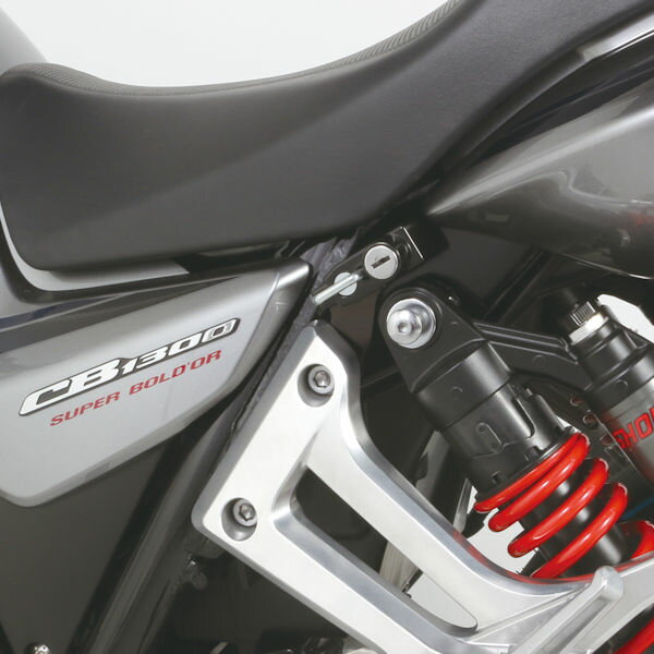 適合車種：HONDA CB1300SF CB1300SB （FNo.SC54-2300001〜） 純正パニアケースやサイドバック装着後の対策に！ ヘルメットホルダー増設！ 　 タンデム時の利便性もアップ ！ 純正パニアケースやサイドバック装着後使用できなくなる 純正ヘルメットホルダーの代用品として増設。 タンデムツーリングでバイクから少し離れる時に ヘルメットを掛けておくのに便利です。 タンデムステップに共締めタイプのヘルメットホルダーが登場です。 ■商品詳細 ●ステー：スチール製ブラック　 ●ヘルメットロックtype2（ボディ：ブラック） ●タンデムステップ共締めタイプ　 ●キー：2ヶ付属（スペア含む）