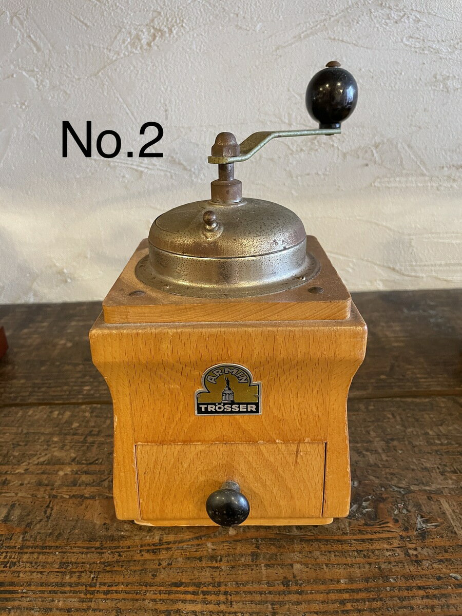 【 ＃2】 ARMIN TROSSER wood box coffee mill コーヒー専門店が厳選する本物のアンティークミル 商品番号：2メーカー：ドイツ ARMIN TROSSER社大きさ：W17.5 cm×D14 cm×H24 cm（突起部含む）製造年：1940年代状態：A（大変良好）キズその他瑕疵：ラッカー及びメッキ部に軽度の経年劣化が認められるドイツの主要メーカーARMIN TROSSER社の大型なミルです。表面の塗装ラッカーとホッパー、ハンドルのメッキは劣化があります。ロゴマーク、歯の状態は良好本体の欠け、反りはありません。ARMIN TROSSER社はドイツのPEDE社と並ぶ優良なメーカーでした。造りがしっかりしており現在でも普通に使えるモデルが残っています。1950年代まで製造していました。どっしりとした大型のボックスミル。いかにもドイツらしい風貌です。やや高めの値段はなぜ？写真を拡大すると、本体とドロアー（引き出し）の木目がそろっているのが確認できます。つまり、一枚の板を丁寧に分離して製作しているのです。普通はそんな手間をかけることはしません。しかしこの職人さんは、きれいな木目を生かしたく、わざわざ手間をかけて造り上げています。マウンテンはこういうところにグッときてしまいます。現代では到底つくられない古き良き時代の逸品です。末永くお使いください。※経年変化も大切な味わいと考えているため、研磨は必要最小に留めています。分解清掃は施しておりません。※お使いになられる際は、一度捨て豆で挽かれてからお使いください。※アンティークの性質上、ご購入後の返品、交換等はお断りいたします。 8