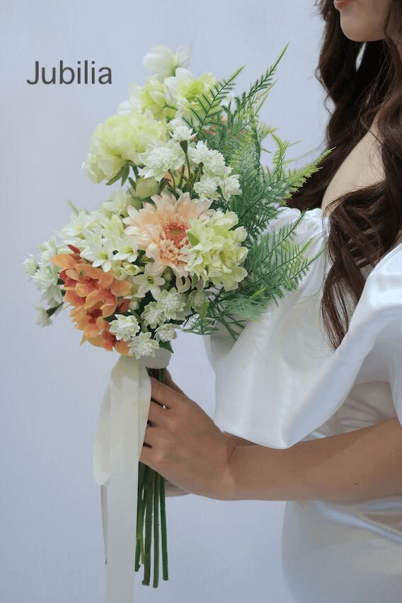 Mrs.四季のHerper（ハーパー）〜天使の演奏〜 ウエディング 結婚式 前撮り ブーケ ブライダル フォトウエディング 造花 花嫁 おしゃれ きれいめ 上品 ナチュラル グリーン オレンジ リリー ガーベラ_02｜アングル3