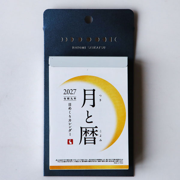暦と寄り添う暮らし、はじめてみませんか？ 2014年の販売開始以来、たくさんのお客様に愛され続けるロングセラーの人気商品「月と暦 日めくり」。 毎日の月の形を大きく掲載した日めくりカレンダーで、月の満ち欠けや二十四節気、七十二候の移り変わりから、日本の美しい季節が楽しめる日めくりです。 金具や紙は昔ながらの日めくりカレンダーと同じつくりです。 --------------------------- 「今日の月」を見上げたくなるカレンダー 「月と暦」は、日本人が大切にしてきた季節や伝統行事を感じながら、月の満ち欠けを楽しめるカレンダーです。 月の名前や季節の名前、旬の花やお祭りなどの伝統行事をミニコラムで毎日ご紹介。 暮らしの中で見過ごしがちな、日々の小さな季節の変化にも気づかせてくれます。 使いやすいミニサイズ 365日分の厚みがあるものの、ちょっとしたスペースにも飾りやすいコンパクトなサイズ感。 夜空をイメージし、月の満ち欠けのイラストをあしらった台紙スタンド付きなので、卓上でも壁掛けでもお使いいただけます。 毎日少しずつ月と暦について学ぶことができるので、季節を感じてほしいお子さんやお孫さんに贈るのもおすすめです。 雪うさぎや風鈴、紅葉など季節を彩るイラストも時々登場し、忙しい日々の中で季節を楽しむ喜びを感じさせてくれます。 掲載日：2027年1月1日から2027年12月31日 サイズ：H175×W95mm 枚数：380枚つづり 金具製本、紙スタンド付き 中国製 ※昔ながらのレトロな製法で製作されています。ざらっとした手触り、薄く漉かれた紙、少したわんだ金具など、昔からの日めくりカレンダーらしさもお楽しみください。 メール便でお送りできます。 【楽ギフ_包装選択】 【がんばろう！宮城】 【東北復興_宮城県】