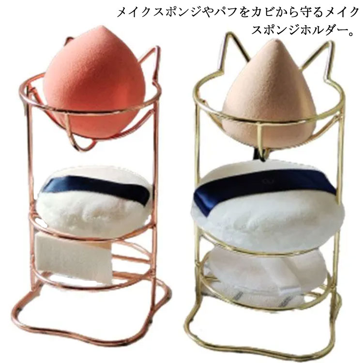 メイクスポンジやパフをカビから守るメイクスポンジホルダー。通気性を考えたデザインになっており、自然乾燥させるのに便利です。こだわりの曲線デザインでメイクスポンジにも跡がつかないのも嬉しい♪3段式で、斜めカットや卵型、ハート型、スター型などのメイクスポンジやパフも收納できます。可愛い猫耳デザインも魅力♪置くだけでスポンジを可愛く収納出来ちゃうんです♪ サイズ F サイズについての説明 1段：直径6.5cm 2段：直径7.5cm 3段：直径5.5cm1段to2段：高さ4cm 2段to3段：高さ2.8cm 素材 金属 色 ピンクゴールド ゴールド 備考 ●サイズ詳細等の測り方はスタッフ間で統一、徹底はしておりますが、実寸は商品によって若干の誤差(1cm～3cm )がある場合がございますので、予めご了承ください。 ●製造ロットにより、細部形状の違いや、同色でも色味に多少の誤差が生じます。 ●パッケージは改良のため予告なく仕様を変更する場合があります。 ▼商品の色は、撮影時の光や、お客様のモニターの色具合などにより、実際の商品と異なる場合がございます。あらかじめ、ご了承ください。 ▼生地の特性上、やや匂いが強く感じられるものもございます。数日のご使用や陰干しなどで気になる匂いはほとんど感じられなくなります。 ▼同じ商品でも生産時期により形やサイズ、カラーに多少の誤差が生じる場合もございます。 ▼他店舗でも在庫を共有して販売をしている為、受注後欠品となる場合もございます。予め、ご了承お願い申し上げます。 ▼出荷前に全て検品を行っておりますが、万が一商品に不具合があった場合は、お問い合わせフォームまたはメールよりご連絡頂けます様お願い申し上げます。速やかに対応致しますのでご安心ください。