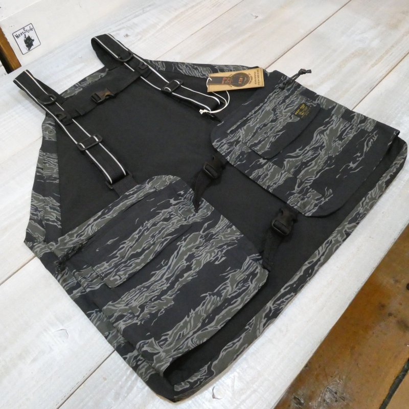 【WEST RIDE】 ウエストライド オンザロードベスト ゲームベスト/ツーリングベスト ナイトタイガーカモ MADE IN JAPAN ON THE ROAD VEST 「路上を走る為」のベストは「安全性」にも着目しながら誕生した機能的でスタイリッシュな一枚です。 SUPPLEX糸を使用した3層の完全防水オリジナルファブリックで製作。 前後のポケットは2重構造となりフロントは止水ジッパーポケットと止水テープ処理を施したフラップ＆ベロクロ付きのポケット。 背面は下部に水抜きドレンを採用した20ℓの大容量ポケットとリフレクターテープ付きのフラップ・ベロクロ付きポケット。 ポケット内部は防水、内部をシーム処理仕上げです。 着用時の安定力を増すチェスト・ストラップと調整できるクイックバックル。 ショルダーストラップにもリフレクターパイピングで夜間の前後からの視認性をも確保しています。 素材　：ナイロン100% 配色　：ナイトタイガーカモ 展開　：38(M)・40(L)・42(XL) 【サイズスペック】 38　：身幅53.0　着丈59.0cm 40　：身幅57.0　着丈63.0cm 42　：身幅61.0　着丈66.5cm ※任意で選び採寸しておりますので個体差によりスペックは前後する場合があります。 　サイズは現状優先となりますのでご了承下さい。