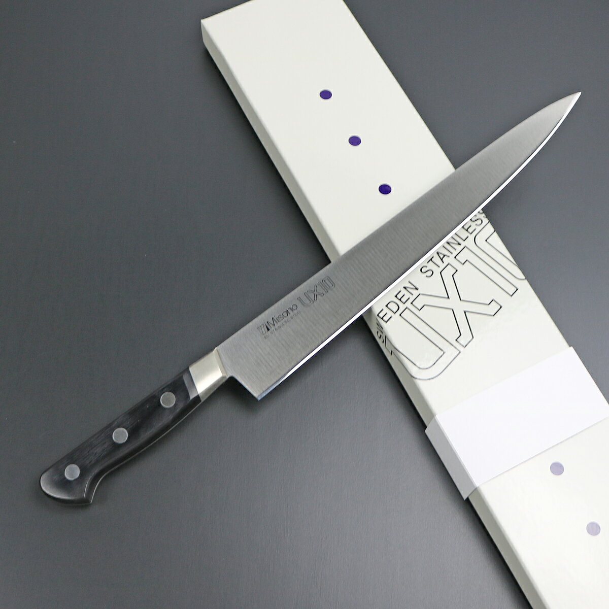 MISONO UX10 筋引 270mm ステンレス鋼の特長で錆びにくく、しかも高級炭素鋼と同等の硬度を誇り、研ぎやすく長く切れ味が落ちない。当然、切れ味は鋭いステンレスの包丁。これは料理人の理想と言えるでしょう。UX10シリーズはそれを実現した画期的な包丁と言えます。この包丁こそがステンレス包丁の最高峰です。 ◆サブゼロ処理 焼入れの後に-70℃以下に冷却する特別な処理により高い硬度と靭性をあたえる事で切れ味を一段と高めてあります。 ◆本刃付け プロの技術者によって天然砥による本格的な刃付けが施してあり、鋭い切れ味を発揮します。研ぎ直しも容易です。 ◆ニッケルシルバー使用、高級感あるツバとリベット 切れ味と使いやすさを追求した斜めのデザインが美しい。洋銀（ニッケルシルバー）を使用しシャープな高級感を表現しています。 ◆黒強化木ハンドル最高級品に相応しい高品質の黒強化木を使用しています。堅くて丈夫、しかも天然素材の優しさが手にピッタリとフィットします。使えば使うほど愛着あふれるハイタッチな味わいです。 　 ■刃渡り 270mm ■ブレード材質 スウェーデン産高純度ステンレス ■ハンドル材質 強化木檀（黒） ■リベット材質 洋銀(ニッケルシルバー) ■備考 &nbsp; 贈り物としても 古くは「お守り刀」を贈る風習もありましたが、昨今では刃物は”未来を切り開く” として縁起の良い贈り物としてプレゼントされる方も増えています。 当店では無料でギフトラッピングにも対応させて頂きます。 ニューワールドネット名品倶楽部 ニューワールドネット名品倶楽部を運営する（株）北正は、 「刃物の街」岐阜県関市で創業から約70年以上にわたり 一貫して刃物を取り扱っております。 岐阜県関市を中心に、優れた刃物を提供する事をモットーにしており、 長年にわたる豊富な経験と実績をもとに、刃物のプロによって選定された刃物 （ナイフ、包丁をはじめハサミ、爪切り等）は信頼できるものばかり。