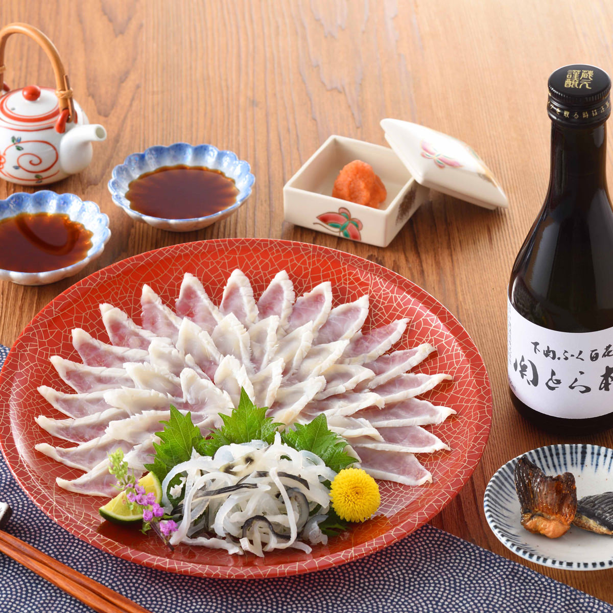 「下関 関とら本店 天然ふく刺身 日本酒 焼きヒレ セット」は、自宅で本格的なふぐ料理とお酒を愉しめる贅沢な晩酌セットです。「天然真ふく刺身」、冷やしても燗にしても美味しい「関とら本店オリジナル吟醸酒」、ヒレ酒用に炙り焼きした「とらふく焼きヒレ」を詰め合わせました。本場下関の職人が一枚一枚丁寧に美しく盛り付けた「天然真ふく刺身」は、天然ならではのしっかりとした歯ごたえと繊細で上品な甘みが特徴です。噛めば噛むほど旨味が口の中に広がります。さらにコリコリとした食感がクセになる「とらふぐ皮」も添えています。関とら本店オリジナル吟醸酒は、冷酒でも熱燗でも美味しく、ふくの旨みと絶妙に調和し、より一層その味わいを引き立てます。香ばしく炙った「とらふぐ焼きヒレ」を熱々の日本酒に加えて、ヒレ酒を楽しむのもおすすめ。とらふくヒレの風味がしっかり溶け込み、贅沢なひとときを演出します。※お酒20歳になってから。妊娠中や授乳期の飲酒は胎児・乳児の発育に影響を与える恐れがあるので気をつけましょう。飲酒運転は法律で禁止されています。【名称】ふぐ刺身と清酒詰合せ【数量・内容】真ふぐ霜降り刺身(25cm皿)70g、とらふぐ皮30g、日本酒(関とら本店)300ml、ふくポン酢10g×2、もみじおろし10g×2、とらふぐ焼きヒレ2枚【賞味期限】出荷日含め80日【原材料】原料ふぐの種類(標準和名：トラフグ、マフグ)日本酒(米(国産)、米こうじ(国産米)、醸造アルコール)、刺身(マフグ(山口県産))、皮(トラフグ(長崎県産、熊本県産:養殖))、ふくポン酢(醤油、柑橘果汁(橙、かぼす)、醸造酢、米発酵調味料、かつおエキス、昆布エキス、食塩/調味料(アミノ酸等)、(一部に小麦・大豆を含む))、もみじおろし(大根、澱粉、唐辛子、こんにゃく粉、梅酢)、とらふぐ焼きヒレ(トラフグ(国産))【アルコール】関とら本店　15％【アレルギー情報】掲載商品には、アレルギーの原因といわれる原材料を含んでいる場合がございます。 くわしくはお問い合わせフォームにてご連絡ください。類似商品はこちら下関 関とら本店 ふくちり 日本酒 焼きヒレ 5,400円下関 ふぐ屋 やまにし とらふぐ 刺身 鍋 ヒ7,500円とらふく刺身セット 約3人前 ふぐ刺し セット10,800円とらふく刺身セット 約2、3人前 ふぐ刺し セ9,720円とらふく刺身セット 約2人前 ふぐ刺し セット6,480円下関 関とら本店 ふくちり 鍋セット ポン酢 3,780円ふくたたきと塩辛セット ふぐ刺し セット 刺身5,400円ふく料理フルコース 約4、5人前 刺身 鍋セッ32,400円とらふく刺身・とらふく塩辛セット 刺身 塩辛 32,400円新着商品はこちら2026/10/19やま磯 味のり 卓上バラエティセット ギフト 4,060円2026/10/19みのり工房 みちのく寒流のり 鹿児島茶 煎茶 4,060円2026/10/19みのり工房 みちのく寒流のり 鹿児島茶 上煎茶5,121円再販商品はこちら2026/10/20純系名古屋コーチン100％ ボーンブロススープ7,344円2026/10/20純系名古屋コーチン100％ ボーンブロススープ10,044円2026/10/18SWAN conee かき氷器23,045円