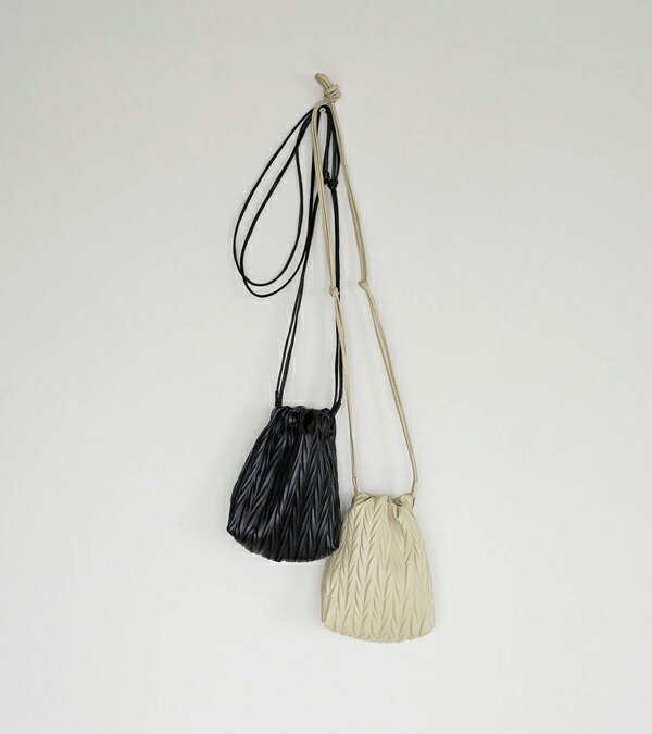 [ anuke / アンヌーク ] ◇Ecoleather Pleats Purse やわらかなエコレザーにプリーツ加工を施し 立体的なヘリンボーン柄に仕上げた巾着バッグ。 表情のある素材感が、スタイリングにさりげない奥行きを添えます。 細めのショルダー紐で、肩掛けや斜め掛けなど その日のバランスでアレンジが可能。 持つだけで自然と雰囲気が出る、デイリーに取り入れやすいアイテムです。 NO：62621016 ■カラー アイボリー、ブラック ■サイズ 【F】高さ18cm、幅15cm、マチ8.5cm、持ち手77cm ■素材 表地　合成皮革　裏地　ポリエステル100% ■原産国 中国