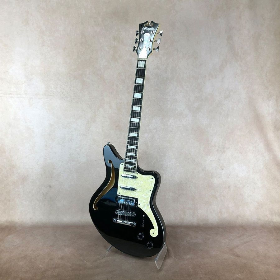 ＝＝＝＝＝＝＝＝＝＝＝＝＝＝＝＝＝＝ この商品はアウトレット・モデルです。 アウトレット・モデルとは、キズ、塗装むら、パーツに錆びやくもりなどがある商品のことを意味します。 従って、これらに起因する修理につきましては、お客様のご要望により有償修理とさせていただきます。 但し、楽器本来の性能やサウンドにつきましては特に問題のない商品ですので、 その他の修理(例：「音が出なくなった」「音がつまる」等)につきましては、保証規定に従いまして修理させていただきます。 ＝＝＝＝＝＝＝＝＝＝＝＝＝＝＝＝＝＝ Premier Bedford&#174; SHは、オリジナルの13.25インチ(336.55mm)幅の1960年代を思わせるオリジナル・オフセット・ボディー・シェイプを基本に6弦側に大きなfホールを備えたセミ・ソリッド構造が特徴で、セイモア・ダンカン・デザインのピックアップをSSHでレイアウトしたモデルです。 ディアンジェリコらしさを感じるオリジナル形状のピックガードは、fホールの一部を思わせるデザインで、ボディー・カラーに合わせたカラーとなっています。 ヘッドストックとネックにはバインディングが装飾され、ホワイト・パーロイドのブロック・ポジションマーカーと組み合わせたデザインです。 ボディー・マテリアルはバスウッドで、メイプル・ネックにオバンコール・フィンガーボードといったウッド・マテリアルを用いています。 ネック・フィニッシュはサテンで、24. 75インチ(628mm)のスケールを採用し、ネック・ジョイントは独自のヒールレス設計で、スルー・ネックのようにボディーの奥(フロント・ピックアップ全体をカバーする位置)までネックを到達させることで接着面積を広く取り、ハイフレットでの演奏性と強度を併せ持った「セット・スルー」ネック・ジョイントとなっています。 さらに、デュアル・アクションのトラスロッドを搭載し、ヘッド側で調整するようになっています。 特徴的なヘッドストック・デザインはディアンジェリコの伝統を継承しています。 トラスロッド・カバーはアルミニウム製で、1930年頃にニューヨークで流行したアール・デコ建築(エンパイア・ステート・ビルディングなど)が建ち並ぶニューヨークの摩天楼にインスパイアされた存在感のあるデザインです。 ピックアップは、メタル・カバードのセイモア・ダンカン・デザインのMH-102ミニハムバッカー(ブリッジ)とTE-103シングルコイル(ネック&ミドル)のSSHレイアウトとなっています。 コントロールは1ヴォリューム、1トーン、5ウェイ・ピックアップ・セレクターのレイアウトです。 ハードウェアはクロームで統一し、チューニングの安定を実現したグローバーのスーパー・ロトマティック、チューンOマティック&ストップ・バー・テイルピースの組み合わせです。 カラーは、グロス・フィニッシュのブラック・フレークです。 持ち運びに便利なギグバッグが付属します。 ■Headstock Shape: Standard ■Headstock Logo Inlay: Mother of Pearl D'Angelico New York Logo ■Headstock Series I nlay (Front): Mother of Pearl Premier Shield Logo ■Headstock Serial Number (Back): Model Name, Serial Number ■Headstock Binding: 3-Ply ■Headstock Finish: Gloss ■Headpin: Cupola ■Tuners: Grover&#174; Super Rotomatic ■Strings: D'Angelico Electrozinc 10's (10-46) ■Truss Rod Cover: Aluminum Skyscraper ■Nut Width: 1 11/16" (42.86mm) ■Nut M aterial: PPS ■Fingerboard Material: Ovangkol ■Fingerboard Binding: 3-Ply ■Fretwire: Medium Vintage Nickel Silver ■Scale Length: 24.75"(628mm) ■Radius: 14" (355.6mm) ■Fingerboard Top Inlay: White Pearloid Block ■Fret Number: 22 ■Neck Material: Maple Scarf ■Neck Finish: Natural Satin ■Neck Profile: C-Shape ■Joint Type: Set-Thru ■Truss Rod: Dual Action ■Body Shape: Offset ■Body Style: Semi-solid with Contoured F-Hole ■Body Depth: 1.625" (41.275mm) ■Body Width: 13.25" (336.55mm) ■Body Color: Black Flake ■Body Finish: Gloss ■Body Material: Basswood ■Bridge: Chrome Tune-O-Matic ■Tailpiece: Stopbar ■Pickguard: F-Hole Style, Cream Pearl (5-Ply) ■Back Plate: Black ■Pickup Selector: 5-way Blade ■Knobs: 2 Black Speed Knobs ■Strap Buttons: Chrome ■Electronics Overview: 2 Single Coil / 1 Mini-Humbucker / 1 Volume / 1 Tone / 5-way Blade ■Pickup (Neck): Duncan Designed TE-103 (Chrome Cover) ■Pickup (Middle): Duncan Designed TE-103 (Chrome Cover) ■Pickup (Bridge): Duncan Designed MH-102 (Chrome Cover) ■Pots: 500kΩ ■Output Jack: Standard Mono ■Hardware Color: Chrome ■Case: Gig Bag