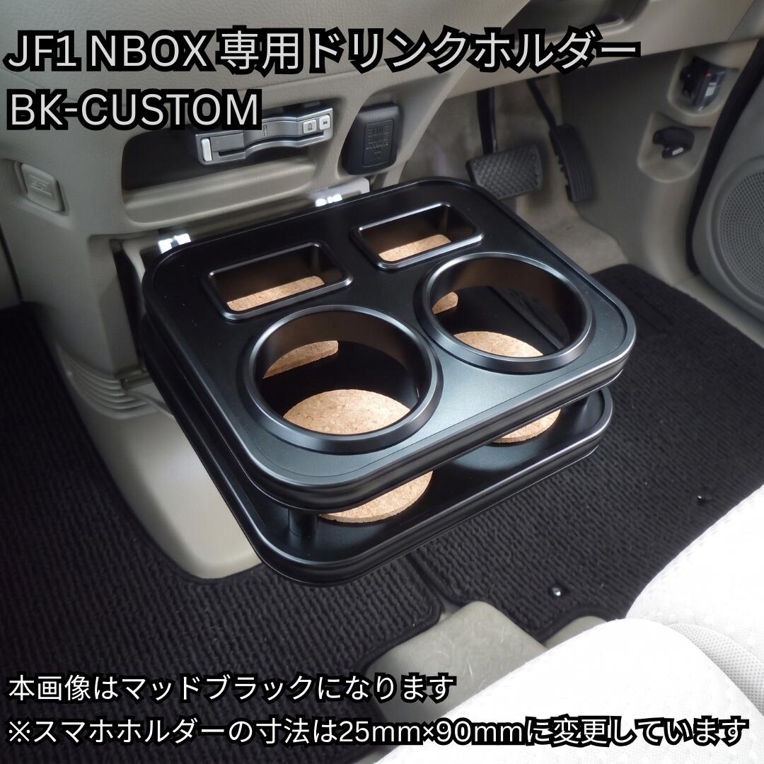 メッキの主張を削ぎ落とした、洗練のオールブラック。 ホンダ N-BOX / N-BOX CUSTOM (JF1/JF2) 専用 フロントカップホルダー 【BK-CUSTOM】 ■ BK-CUSTOM（ブラック・カスタム）とは 通常のメッキモールや金属金具の主張をあえて抑え、モール・リング・固定ピンの細部に至るまで全て「ブラック仕様」に統一した特別ラインアップ。 初代N-BOX（JF1/JF2）の車内インテリアを引き締め、後付け感のないシックで上質なカスタム空間を演出します。 ■ 本商品の専用ホルダー仕様 ・選べるドリンクホルダー × 2個（丸型 または 紙パック対応の四角型） ・大型スマートフォンホルダー × 2個（標準装備） ※用途に合わせてドリンクホルダーの形状がお選びいただけます。 ■ 適合車種・型式 ・ホンダ：N-BOX / N-BOX CUSTOM（N-BOX+ / N-BOXスラッシュは除く） ・型式：JF1（2WD） / JF2（4WD） ・年式：2011年12月〜2017年9月（平成23年12月〜平成29年9月） ※商品画像のカラーはAIにて生成したイメージ画像のため、実際の質感・色味とは若干異なる場合がございます。また、お使いのディスプレイ環境によっても見え方が変わりますので予めご了承ください。メッキの主張を削ぎ落とした、洗練のオールブラック。 N-BOX / N-BOX CUSTOM (JF1/JF2) 専用 フロントカップホルダー 【BK-CUSTOM】 100%自社工場製造（日本製） / one creation オリジナルブランド ■ BK-CUSTOM（ブラック・カスタム）とは 通常のメッキモールや金属金具の主張をあえて抑え、モール・リング・固定ピンの細部に至るまで全て「ブラック仕様」に統一した特別ラインアップ。 ロングセラー軽自動車N-BOX（JF1/JF2）の室内空間に自然と溶け込み、引き締まった上質な空間を演出するone creationこだわりの逸品です。 ■ BK-CUSTOM 5つのこだわりポイント 1. 細部まで徹底したパーツ黒化 モール、ドリンクホルダーリング、固定ピンまで全てブラックパーツを採用。ガチャガチャ感を排除したスタイリッシュな仕上げです。 2. 厳選された高級感ある6色天板 マットブラック / ピアノブラック / レザーブラック / ウッド / ブラックウッド / ブラックチェリー の6色からお好みに合わせて選択可能。 3. 選べるドリンクホルダー（2タイプ） スタイリッシュな「丸型」、500ml紙パックや四角いペットボトルも置ける「四角型」をご用意。※中央には「大型スマホホルダー×2個」を標準装備しています。 4. 車種専用設計による抜群のフィット感 JF1/JF2 N-BOXのフロント周りへジャストフィット。専用設計ならではの高い一体感を提供します。 5. 安心の100%自社工場製造（日本製） 型取りから仕上げまで、熟練の職人が一つひとつ丁寧に自社工場で制作する高品質モデルです。 ■ 適合情報・商品仕様 適合車種 ホンダ N-BOX / N-BOX CUSTOM（カスタム） 適合型式・年式 JF1 / JF2（2011/12〜2017/09） パーツ仕様 オールブラック仕様（モール・リング・ピン黒化） ホルダー構成 選べるドリンクホルダー（丸型 または 四角型）× 2個 ＋ 大型スマホホルダー × 2個 天板カラー マットブラック / ピアノブラック / レザーブラック / ウッド / ブラックウッド / ブラックチェリー（全6色） 生産国 日本（100%自社工場にて製造） 【掲載画像・カラーに関するご注意】 ・商品ページ内に掲載しているカラー画像は、AIにて生成したイメージ画像となります。実際の製品とは微妙に色味や質感・光沢感が異なる場合がございます。 ・お客様がご利用のモニター、スマートフォン画面等の表示環境によっても見え方が変わりますので、あらかじめご了承ください。 ※受注生産品のため、ご注文確定後のキャンセル・変更はお受けできません。適合型式やカラーをよくお確かめの上ご注文ください。