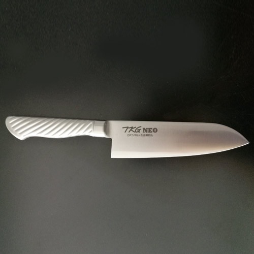 刀身とハンドルが一体化、ハンドルが抜けたり腐ったりしません。 ●TKG-NEO（ネオ）シリーズは、近代化学が生んだクラフト技術（DP法・内部脱炭防止法）を駆使し、刀鋼（3枚複合）はスウェーデン鋼海綿鉄をベースにモリブデン・バナジウム・クロームを添加して、耐摩耗性に優れ、プロ用に設計された庖丁です。 ●DPスウェーデン鋼・スウェーデンで産出した高純度の鉄鉱石をへガネス法と呼ばれる低温ガス還元法で不純物を取り除き、精錬・製鋼された特殊ステンレス合金鋼です。耐食性・耐摩擦性に大変優れており、末永くご使用いただけます。また、DP加工により折れる心配がなく、安全で研ぎ易く仕上げております。 ●SDスウェーデン鋼‐ スウェーデン鋼を主体として、モリブデン、バナジウムを添加して耐摩擦性、抗張性（ねばり）を高め、鋭利性、耐久性、耐錆性、研ぎ易さ等すべて御満足頂ける本職用包丁です。 ●18-8ステンレス鋼製のモナカハンドルは錆びにくく、洗い易い事から従来の木柄ハンドルに比較して、バイ菌の繁殖を防ぎ衛生的です。又、高圧・高温（180℃）殺菌洗浄が可能です。 【全長】290mm 【重量】150g 【背厚】2.0mm 店舗用識別コード：TKG-77-0311-0501 TKG-78-0317-0501