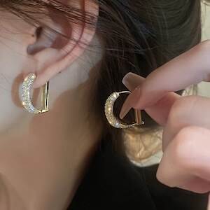 D文字のキラキラビジューが美しい、上品で華やかなゴールドピアスです。大人可愛いデザインでありながら、シンプルで洗練された印象を与えるため、オフィスやビジネスシーンにもぴったりです。また、デートやお出かけ、パーティーやイベントなどの特別な場面でも輝きを放ちます。小ぶりのサイズでありながら存在感があり、さりげないがお洒落なアクセントとなります。さまざまなスタイルやコーディネートにマッチするため、普段使いにも最適です。さらに、軽量で付け心地も良く、長時間の使用でも疲れません。大人の女性に寄り添い、自信や魅力を引き出すパートナーとして、ぜひお手元にお迎えください。きっと、あなたのスタイルを格上げしてくれることでしょう。※お取り扱い時の注意点: 摩擦や水濡れにご注意ください。配送後、ビジューが取れたり変形する可能性がありますので、お受け取り後すぐにご確認ください。【サイズ】2cm×2.1cm8.4g【カラー】ゴールド♪ご注意♪必ず購入前購読事項をお読みの上ご購入をお願い致します。 こちらの商品は海外からのお取り寄せ品です。 お届けまで7日〜1ヶ月前後お時間をいただきます。 ※稀に発注元での製作遅延や国際運輸に遅延が生じ、上記の納期よりお時間がかかることもございます。 その場合大変は恐縮ですがご猶予を賜りますよう、お願い致します。 万が一、発注元で入荷待ち(再製作中)の場合は1ヶ月前後お時間をいただきます。 時期や通関審査によっては1ヶ月以上かかる場合もございます。 予めご了承ください 。 -------------------- また、稀に注文が重なり在庫切れ(再製作なし)となる場合もございます。 そのような場合はすぐに返金手続きをとらせていただきますのでご安心下さい。 お取引の流れ 御入金確定後に商品確保→検品・梱包→お客様へ発送　 お手元に商品が到着するまで1週間〜1ヶ月程度、最大2ヶ月お時間をいただきます。 お急ぎの場合、確実に間に合わせたい予定のある場合に関してはご期待に添えない場合がございますので、上記納期にご了承のうえ購入をお願いします。 ・写真と実物では多少お色が異なって見えることもございます。ご了承ください。 ・イメージ違い・サイズ違いによる返品交換不可 ・輸入品に関しては商品により縫製などが国内製品と比べ劣る場合もございます。 ・サイズ詳細に関しましても上記の都合や、測定の仕方により若干の誤差が生じることがございます。予めご了承ください。 ・輸入の際に、小さな傷・汚れや外箱の破損が生じることがありますが、これらはメーカー側でも返品の対象とならない為、返品・交換はお断りさせていただきます。 ・ご注文確定後のキャンセルはお受け致しませんので、ご了承下さい。 海外発注のため、返品・交換はご遠慮願います。 初期不良品に関しましては購入前購読事項をご確認の上、メールにてご連絡くださいますようお願い申し上げます。 その他、不明点などありましたらお気軽にお問い合わせください。 《商品について》 ※当ショップは海外からのノーブランド商品になります。 海外製品のため日本商品に比べ品質が劣る場合がございます。 糸のほつれ、多少の汚れやシミ、ファスナーが固い、デザインの若干の違いなどは不良品には該当しませんのでご了承ください。 お手持ちの携帯やPCの画面設定の影響により、実物と色味が異なって見える場合がございます。 ※当ショップはお客様より注文を確認した上でメーカーに発注しておりますので返品、交換は出来かねます。ご了承下さいませ。 《発送について》 お取り寄せ商品のため、ご入金確認後、お届けまでに「10-24日程度」のお時間がかかります。 通常よりもお時間がかかってしまう場合もございます。 欠品や商品の不具合などにより、商品をお届けすることができず、ご注文をキャンセルさせていただく場合もございますのでご了承ください。 ※当ショップの商品はお取り寄せ商品につき、入金確認後メーカーへ発注させて頂きます。 ※メーカーにて在庫切れの場合は、速やかに返金させて頂きます。 《返品についての特約に関する事項》 ご注文確定後、発注後のキャンセルやサイズなどの内容変更は承っておりません。 注文時によくご確認ください 商品に欠陥がある場合を除き、基本的には返品や交換には応じません。 最後までご覧くださり、ありがとうございました。 アクセサリー ピアス ゴールド レディース 大人可愛い きれいめ シンプル 上品 お洒落 かっこいい クール モード 華やか オフィス ビジネス OL 通勤 通学 デート お出かけ パーティー イベント 旅行 お買い物 女子会 休日 普段使い 高見え 格上げ モテ 小さめ cn1757