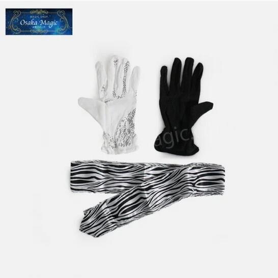白と黒の手袋が白黒デザインのストリーマーに変化！ 商品内容 手袋、ストリーマー ストリーマーの長さ：3m おすすめポイント ステージマジックのオープニングにおすすめ！ 現象 マジシャンは白と黒の別々の手袋をして登場します。 両方の手袋を外し、1つにまとめます。 その手袋を客席に向かって放り投げたかと思うと、手袋がきれいなストリーマーに変化します！ そのストリーマーを手元にまとめて、おまじないを掛けると中からハトが出てくるという演出も可能です。 従来の白黒のストライプのデザインからよりかっこいいヒョウ柄のデザインへと生まれ変わりました！ こちらの方がかっこいいだけではなく手品感が緩和され、よりスタイリッシュに見えます！ ※発送まで2週間程度かかります。