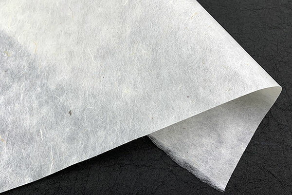 サイズ：約96-100cm巾　1m単位カット売り厚み：並（平均37g/m2）色：ベージュ色に外皮のチリ原料：楮障子紙程度の厚みで透け感のある素朴な紙です。本来はチリとして取り除かれる外皮を漉き込んで利用しています。程よいチリの配合率で少し素朴な障子紙やあかりなどにお使いいただけます。