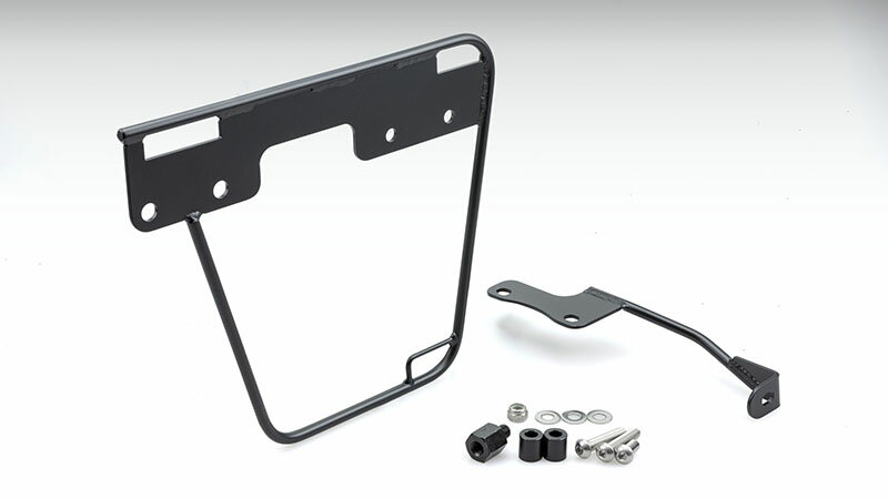 【適合】DAX125(8BJ-JB04) 2022Y- 【材質】スチール 【色】ブラック サイドバッグの装着には欠かす事のできないバッグサポート。ソロでの使用時はもちろん、タンデム乗車時においても使い易い位置を選択できるようにバッグサポートの位置を50mm移動できるフレキシブルな仕様となっております。 バッグサポート本体にベルト固定用のホールを設けている為、容易に確実な固定ができます。 ※純正タンデムグリップおよび当社製リアキャリア（210-2788）の併用が可能。